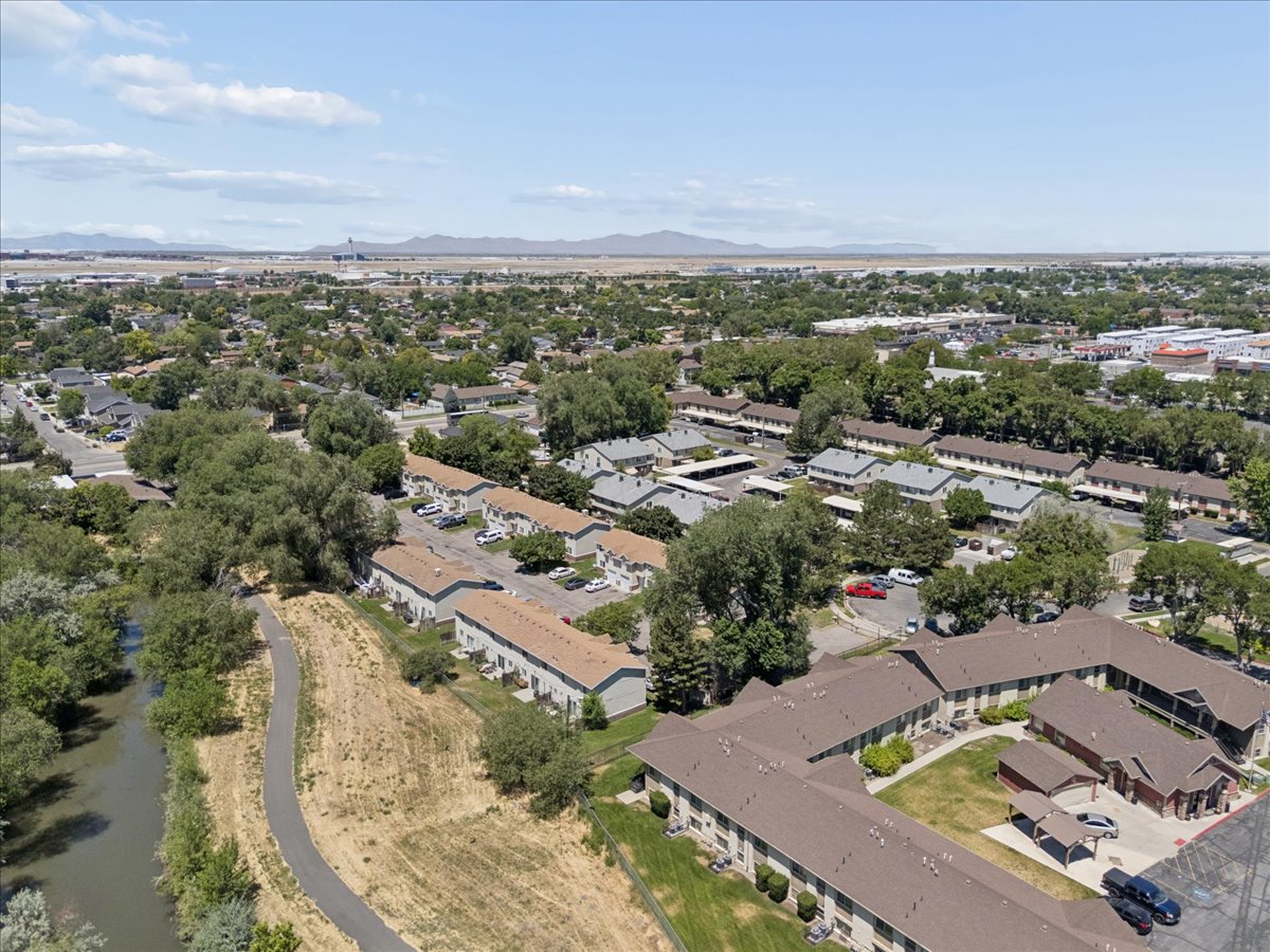 Aerial perspective showcasing a residential community with abundant mature trees and multiple multi-unit buildings