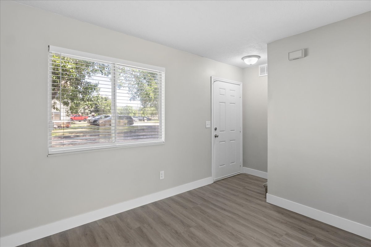 Entry area featuring wood-finish flooring, light gray wall paint, and white baseboards