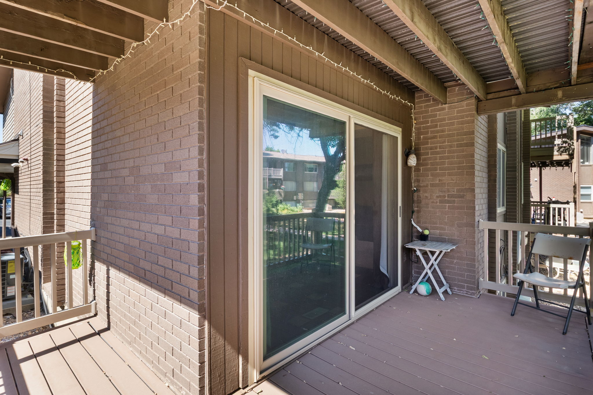 Outdoor patio featuring wood-finish decking and a sliding glass door