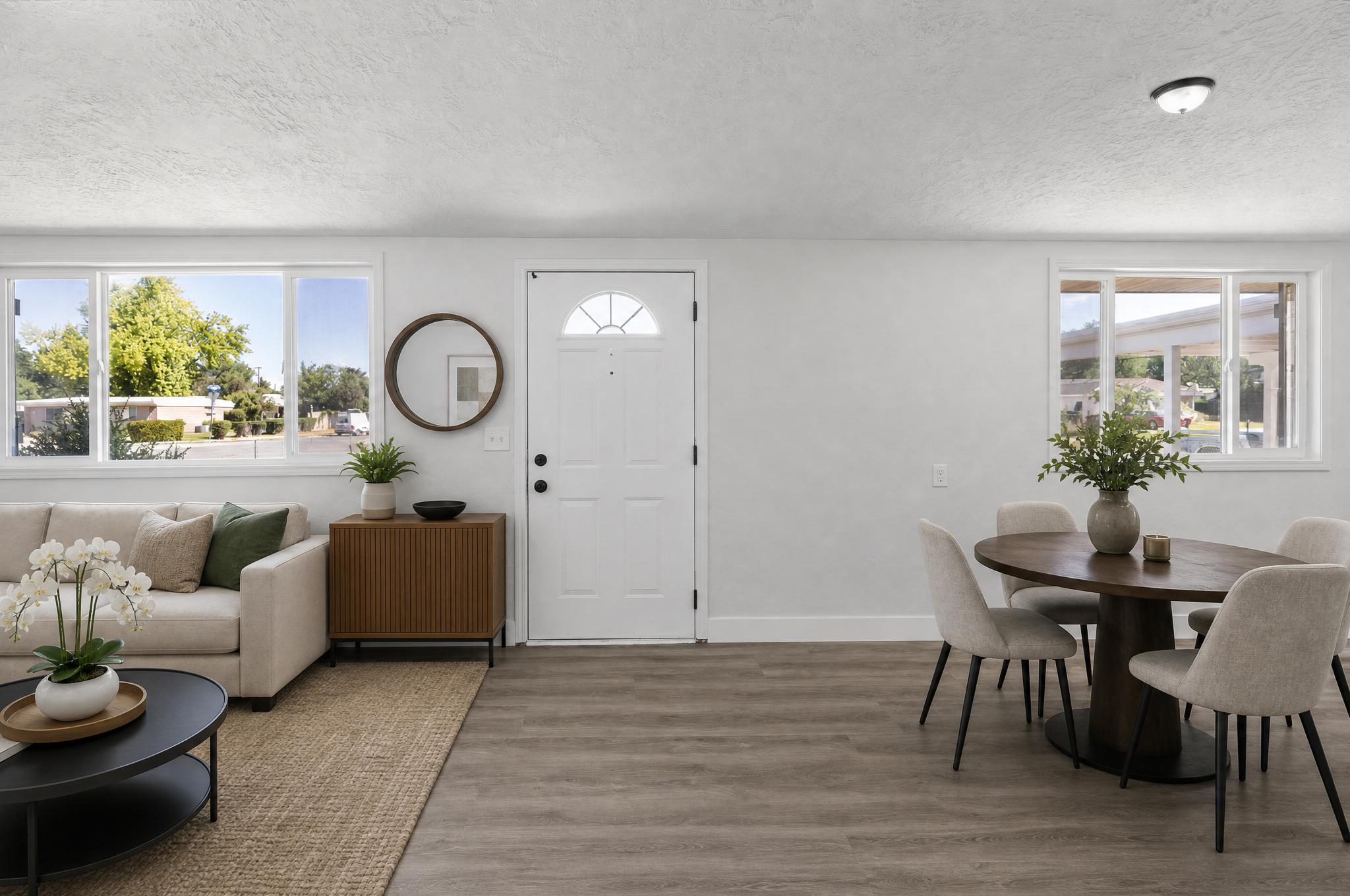 Open-concept living space with neutral wall tones and wood-finish flooring