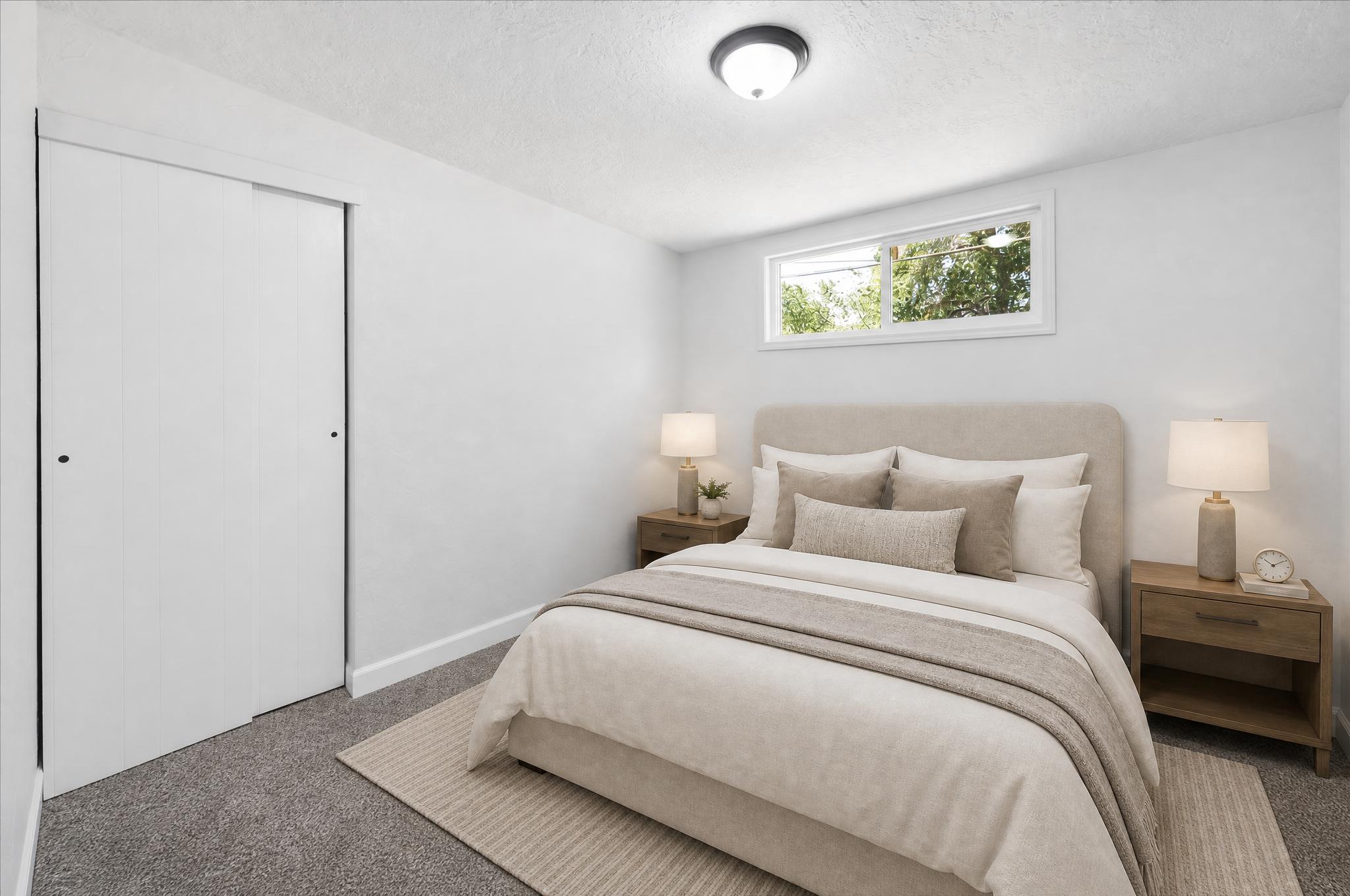 Bedroom featuring a high window, neutral wall paint, and gray carpet flooring