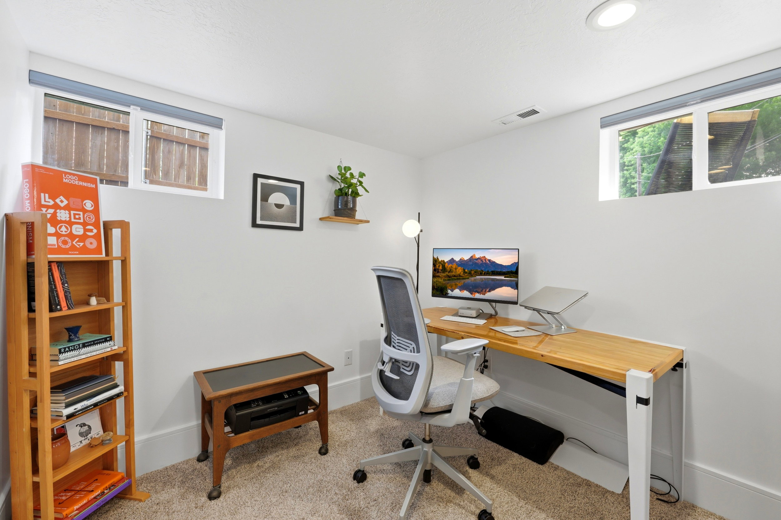 Dedicated workspace featuring recessed lighting, two windows, carpeted flooring, white walls, and a built-in wall shelf