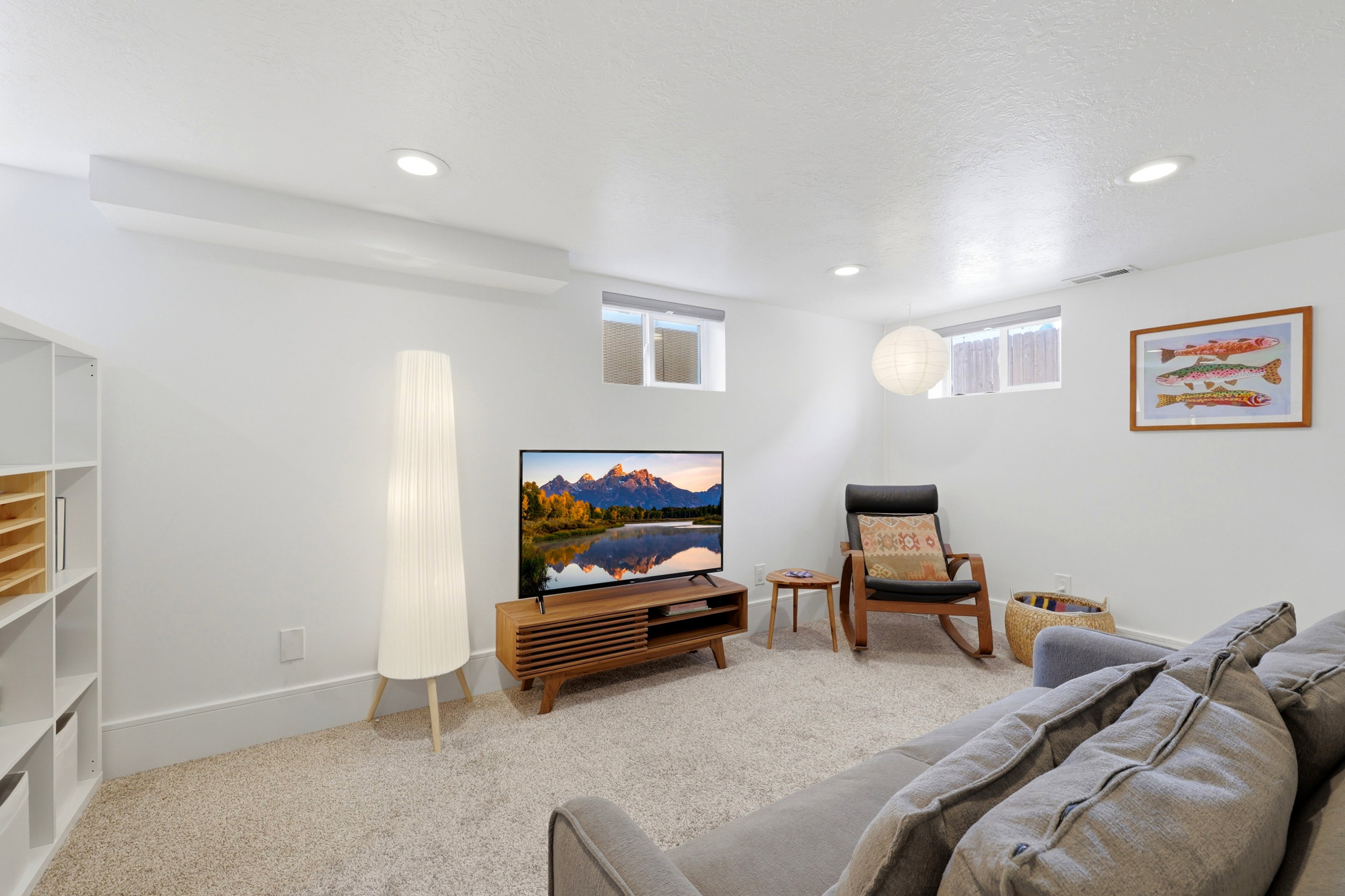 Carpeted living space with white walls and recessed lighting