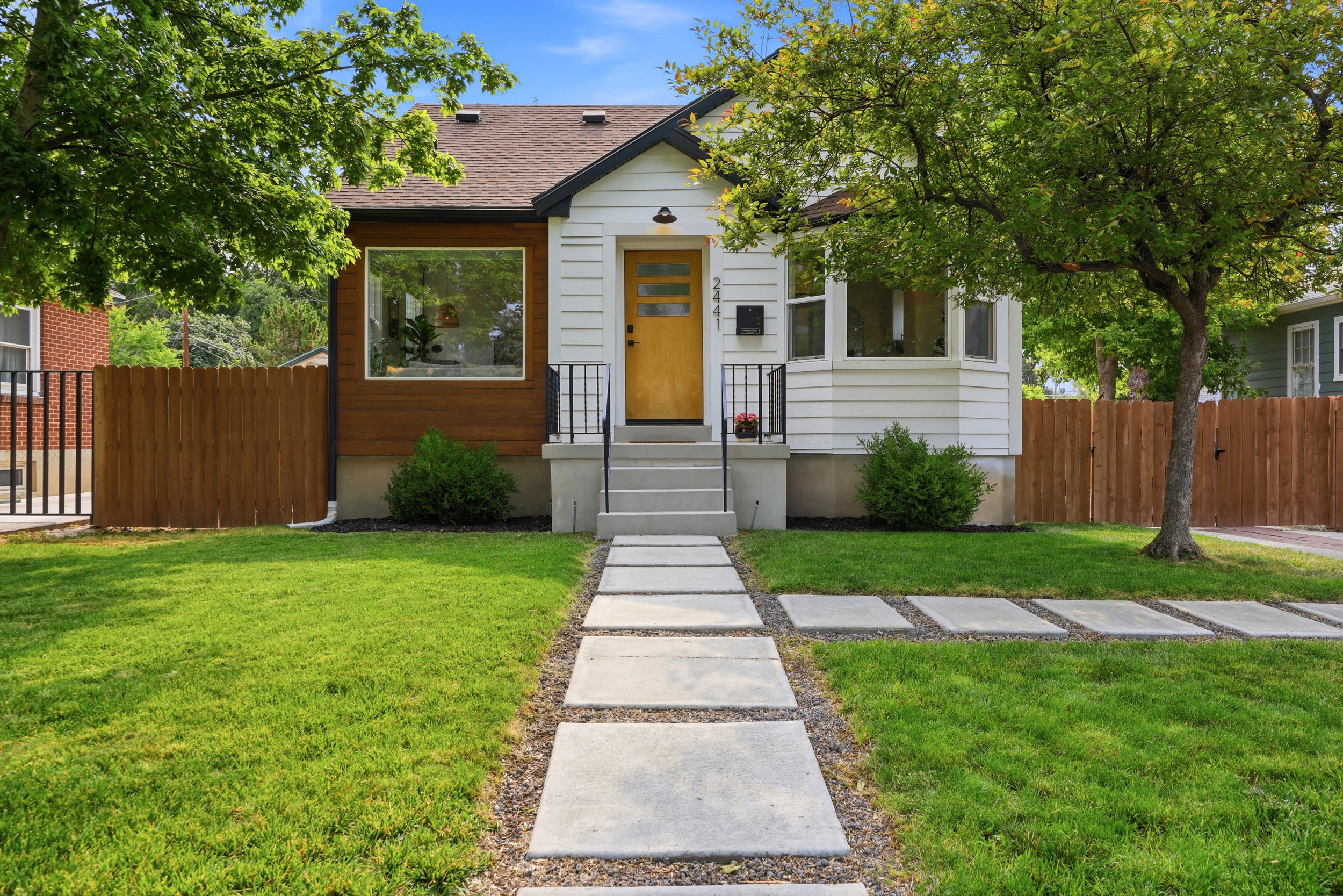 Contemporary facade featuring white siding with wood-finish accents
