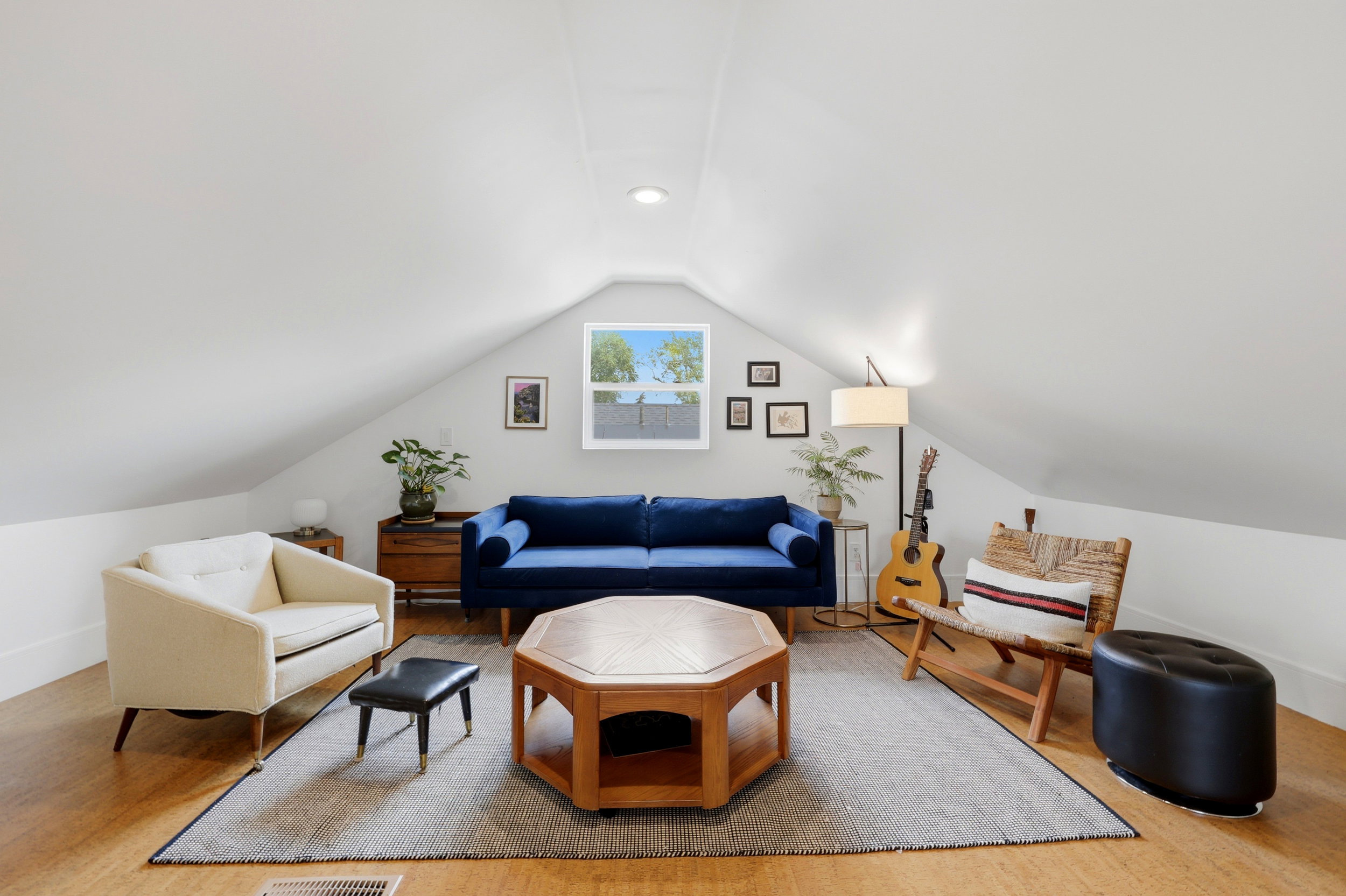 Versatile bonus room featuring light wood-finish flooring, a central window, recessed lighting, and sloped ceilings