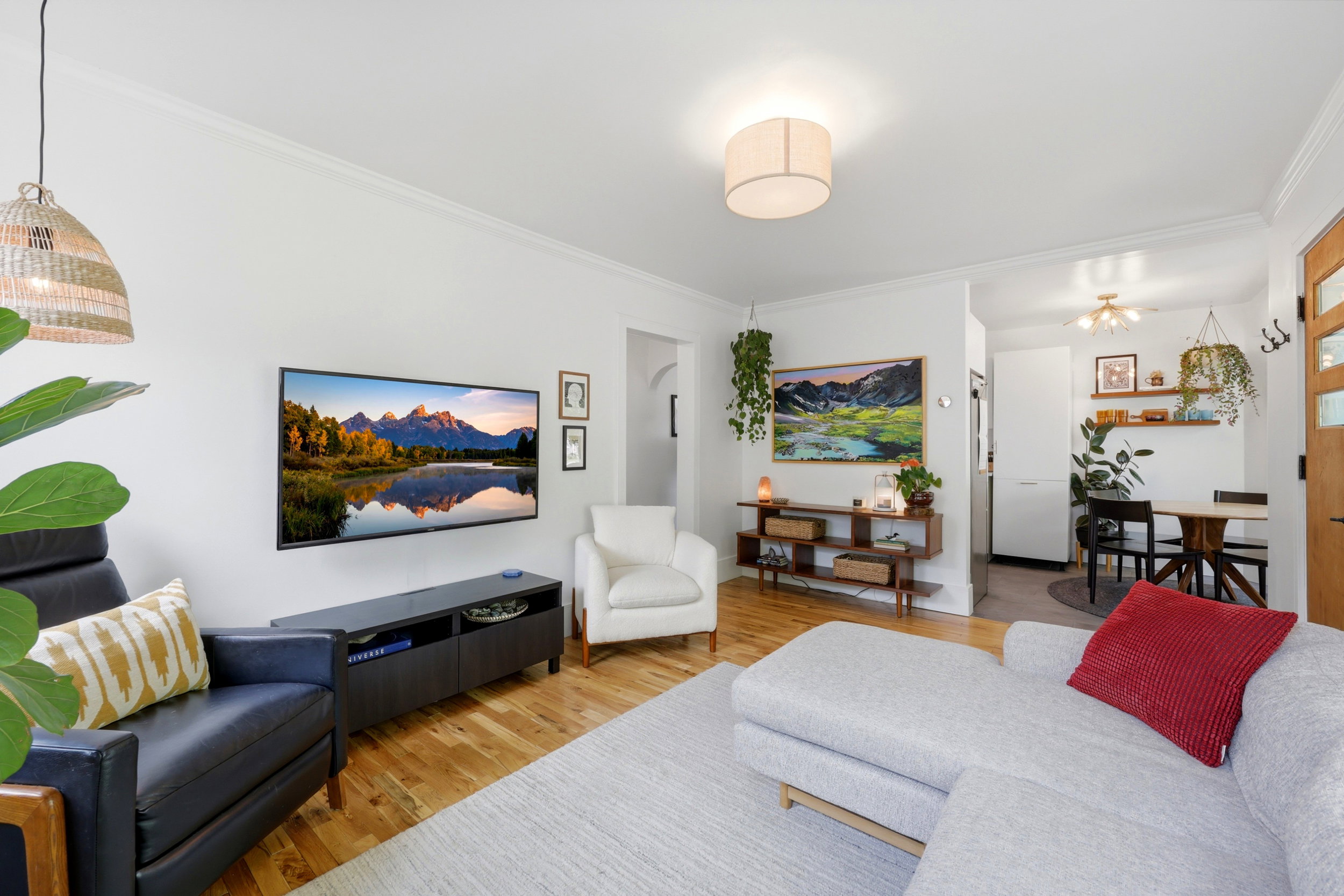 Living area featuring wood-finish flooring, white painted walls, and crown molding