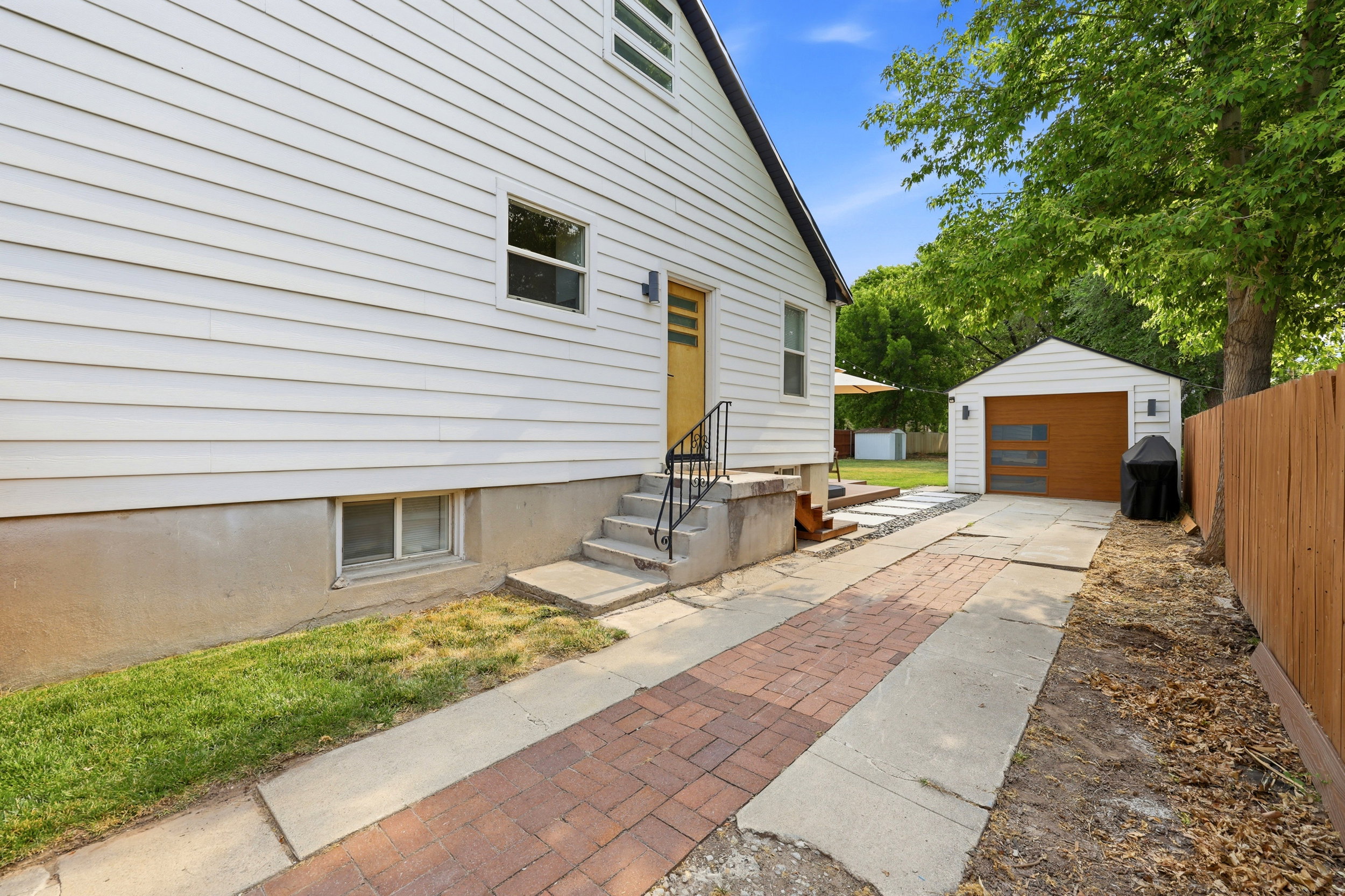 Exterior siding with a window, concrete steps, and a side entry door