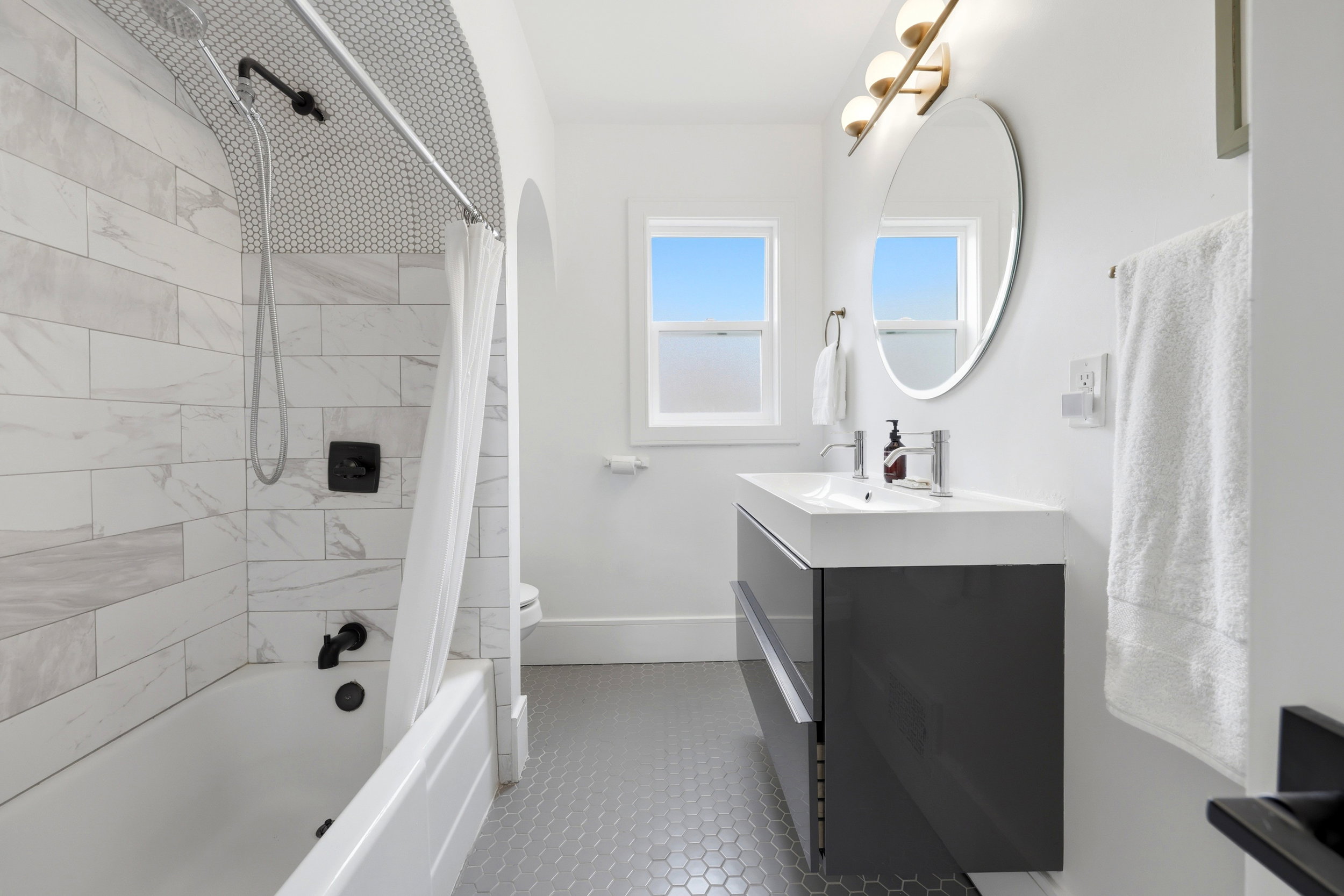 Modern bathroom featuring a single floating vanity with an integrated sink and chrome fixtures