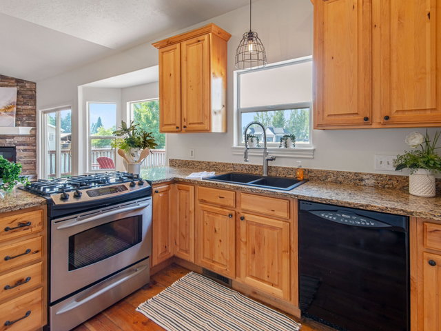 Kitchen featuring wood-finish cabinetry, granite countertops, and stainless steel range