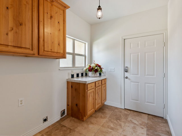 Utility room featuring natural wood cabinetry.