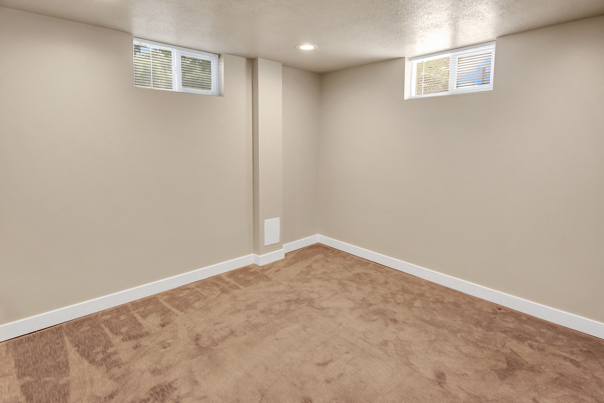Carpeted room featuring neutral wall paint, two high-set windows with blinds, recessed ceiling lighting, and white baseboards