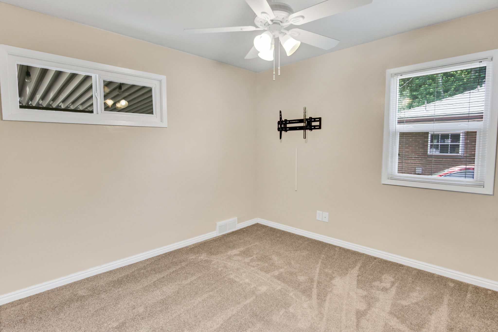 Neutral-toned room featuring light beige walls and complementing carpet flooring