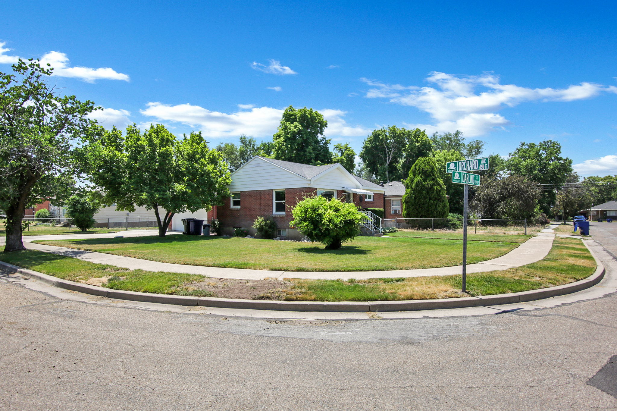Corner lot property featuring a brick exterior and a white roof