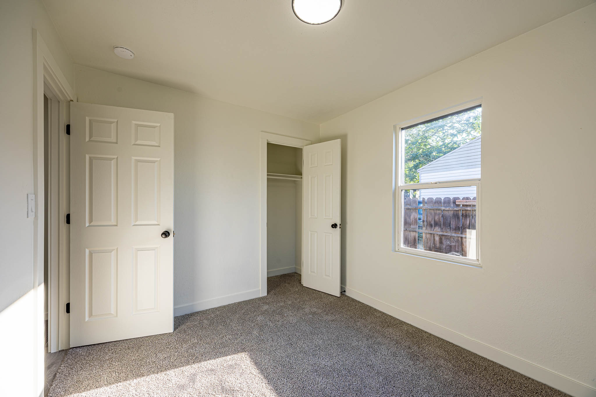 Neutral interior featuring light-colored walls and grey carpet flooring