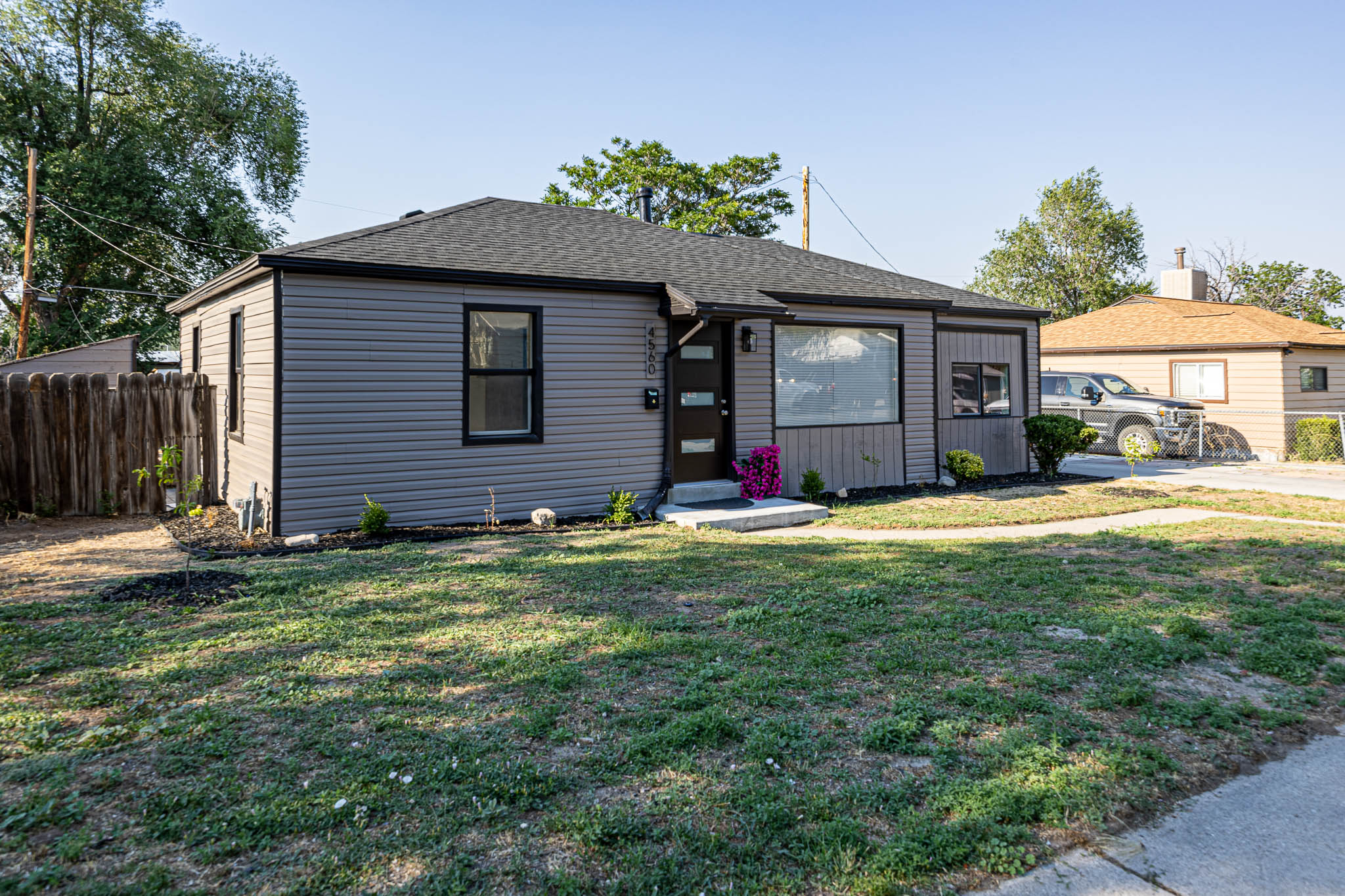Ranch-style exterior featuring gray horizontal siding and a dark shingle roof