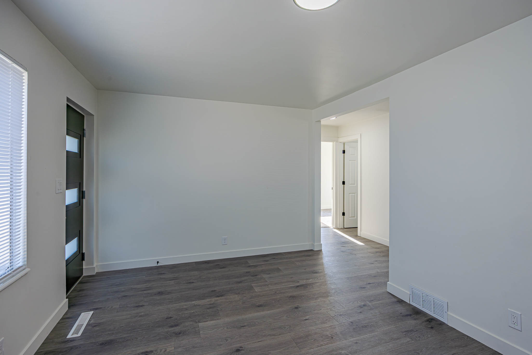 Bright interior space featuring wood-finish flooring and crisp white walls