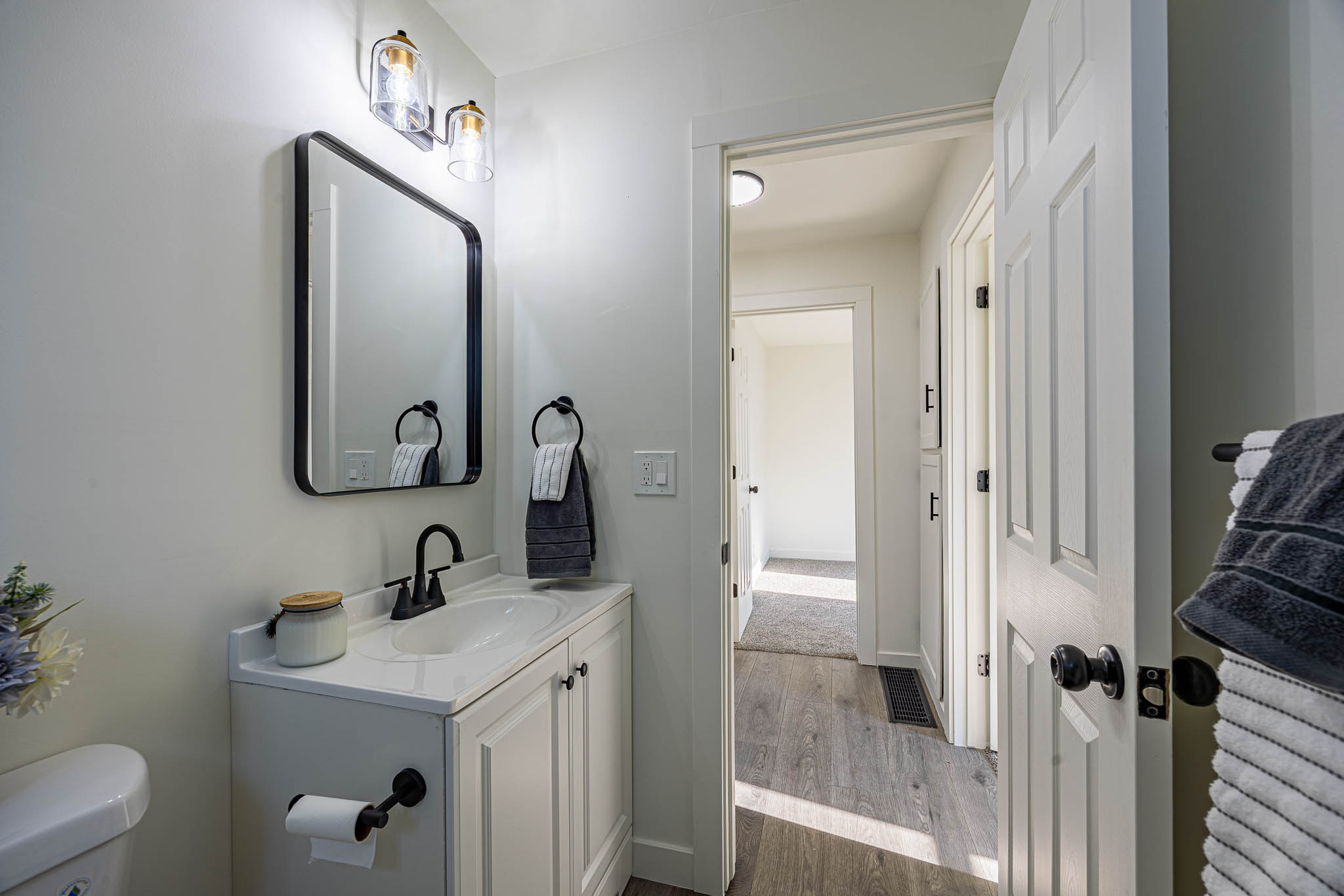 Modern vanity featuring a white countertop, undermount sink, and matte black faucet