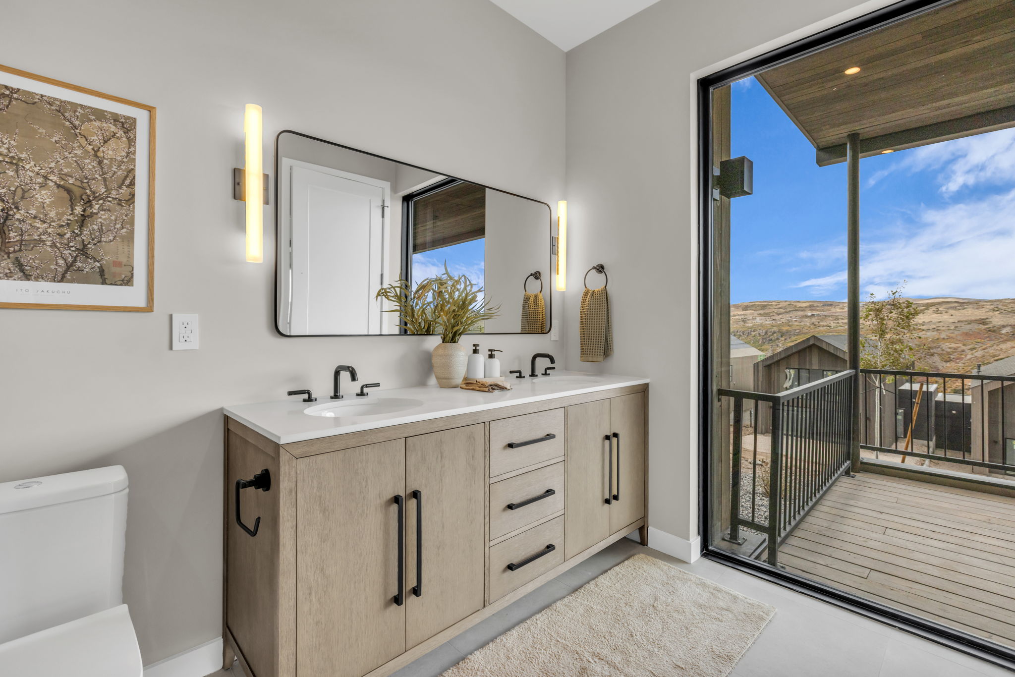 Modern bathroom vanity with dual sinks, matte black fixtures, and a large rectangular mirror