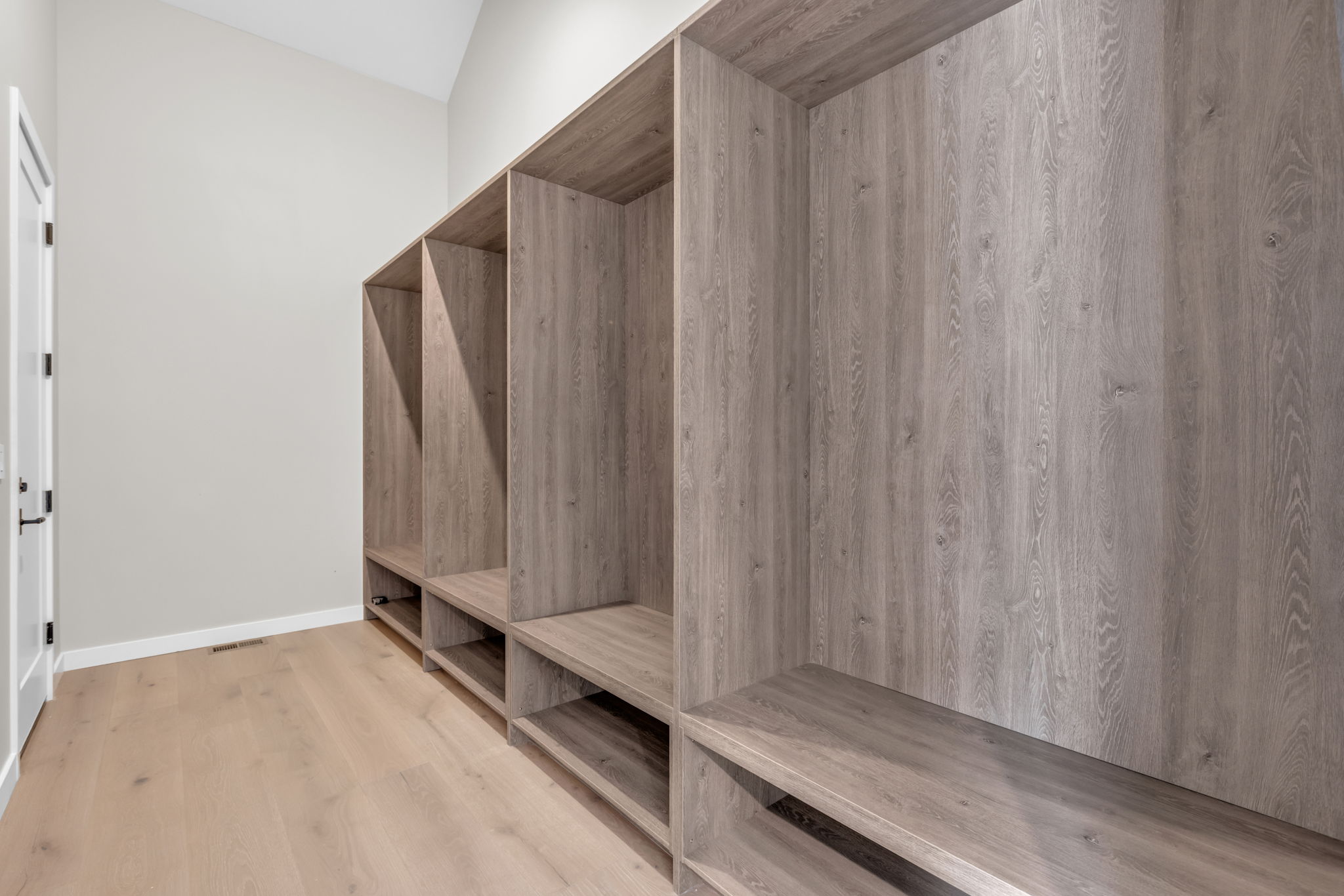 Entryway featuring custom built-in wood-finish cubbies with integrated shelving