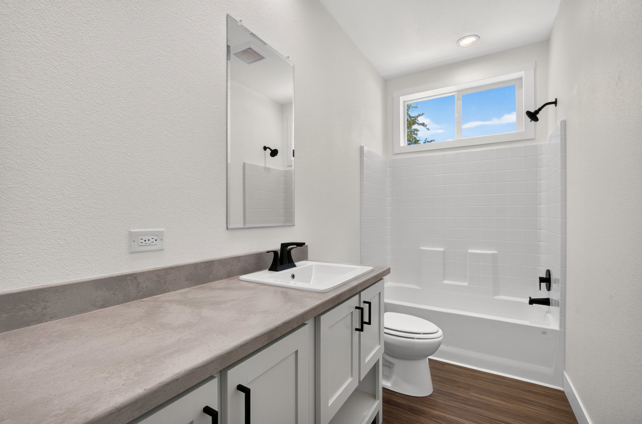 Bathroom featuring a white vanity with gray countertop, undermount sink, and matte black faucet