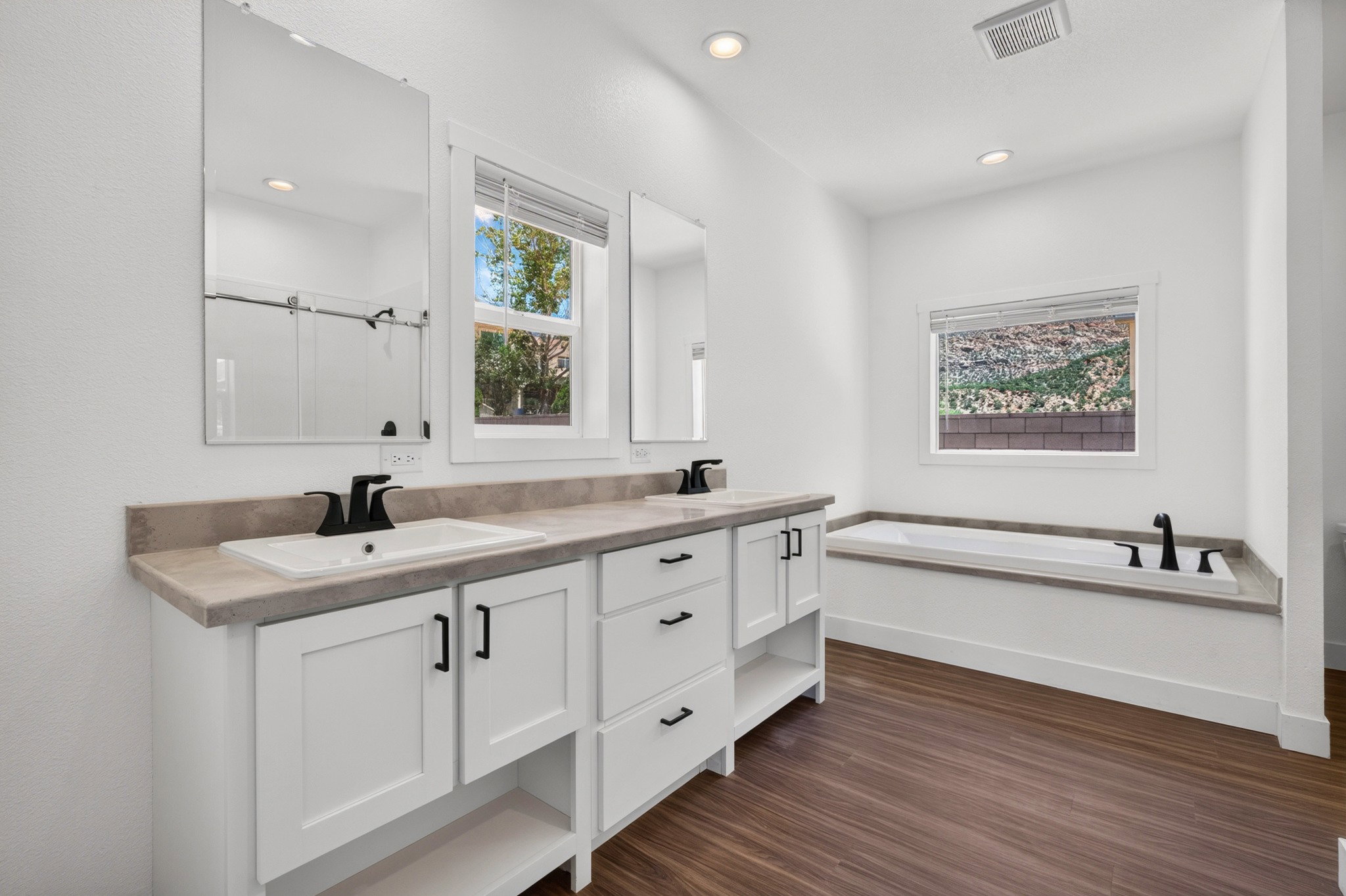 Dual sink vanity with white cabinetry and dark hardware