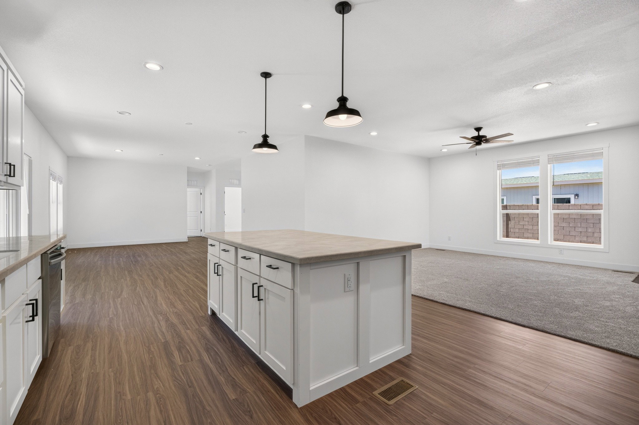 Kitchen featuring a central island with white cabinetry and a light-toned countertop
