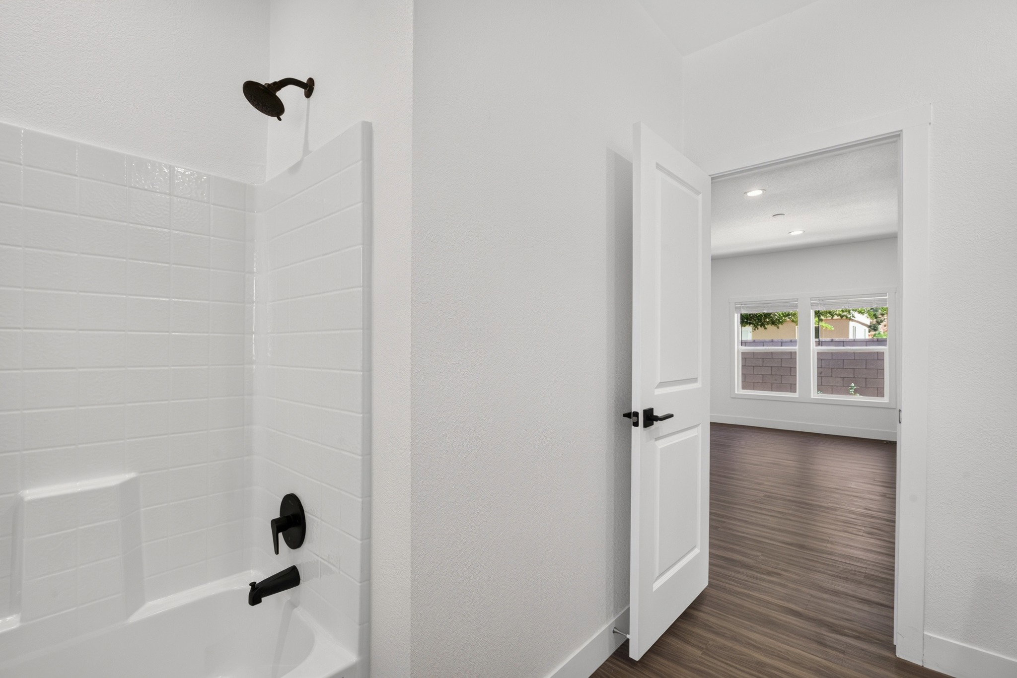 Full bathroom featuring a white subway tile tub surround, black finish shower fixtures, and a built-in tub niche