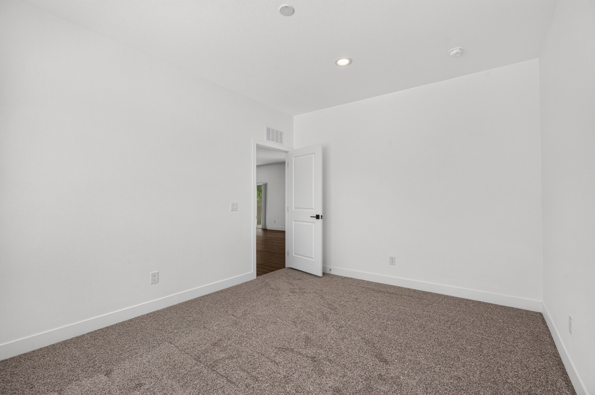 Carpeted room featuring white walls and recessed lighting