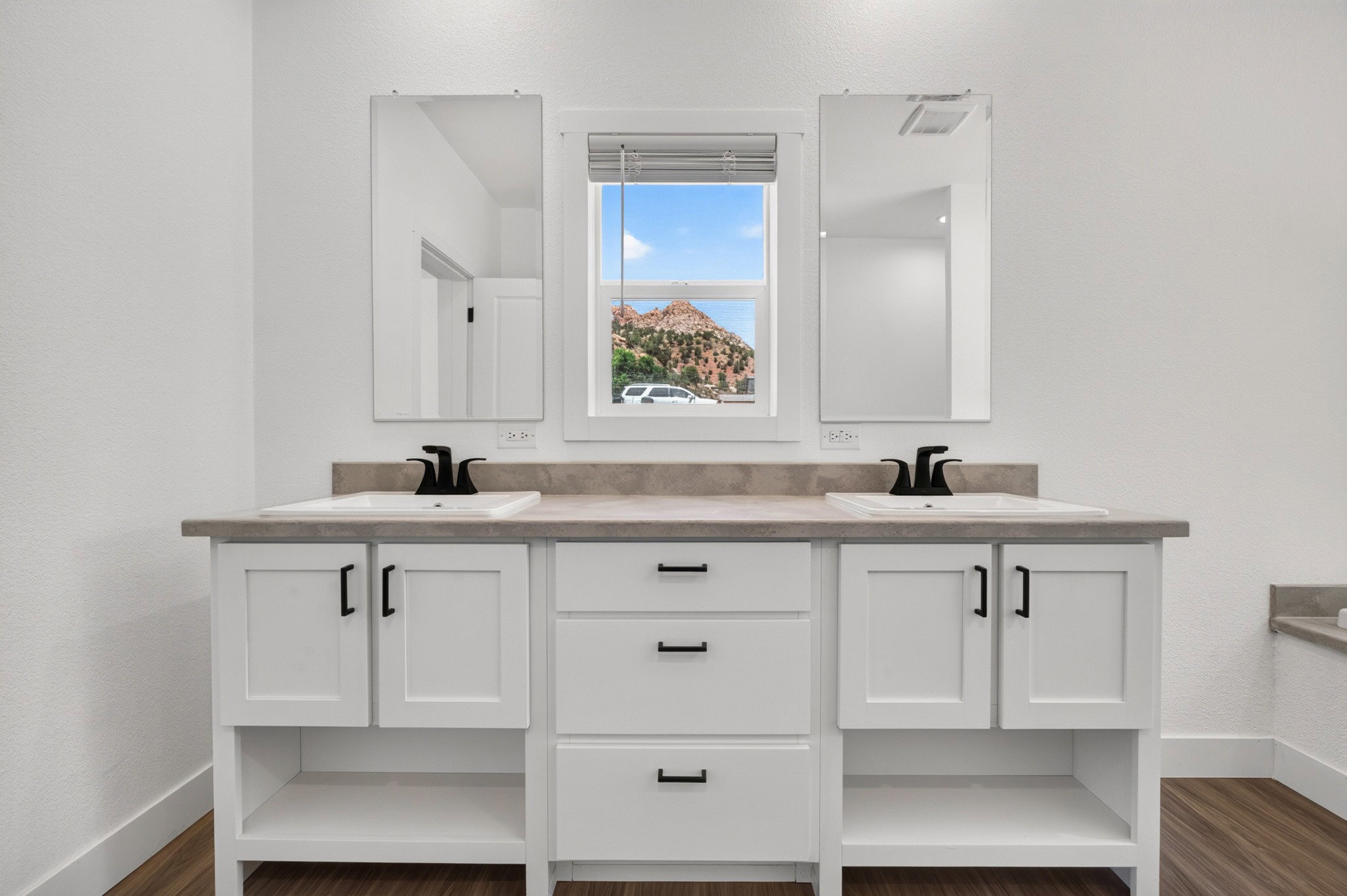 Dual vanity with white shaker-style cabinetry, square undermount sinks, and matte black faucets