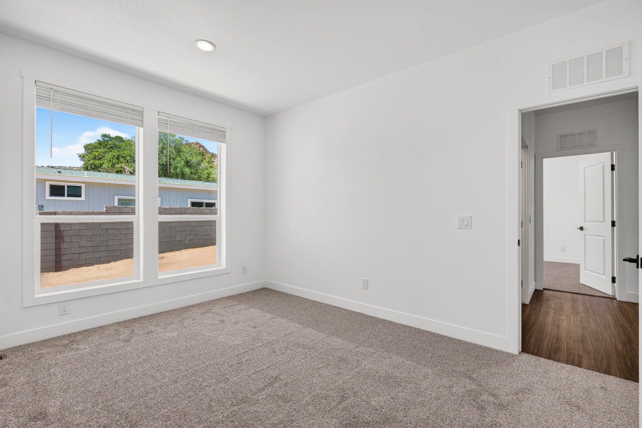 Bright interior space with dual windows and neutral carpeting