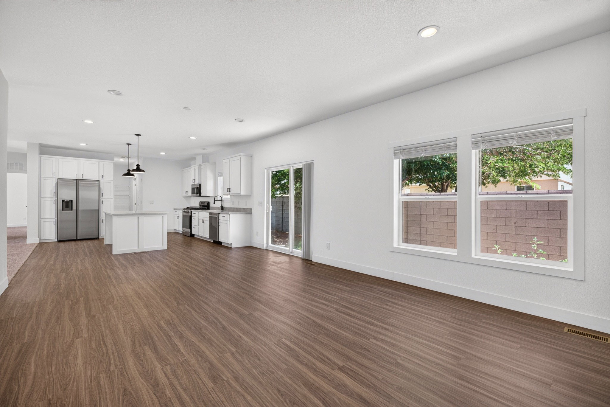 Open-concept living space featuring wood-finish flooring, recessed lighting, and a modern kitchen