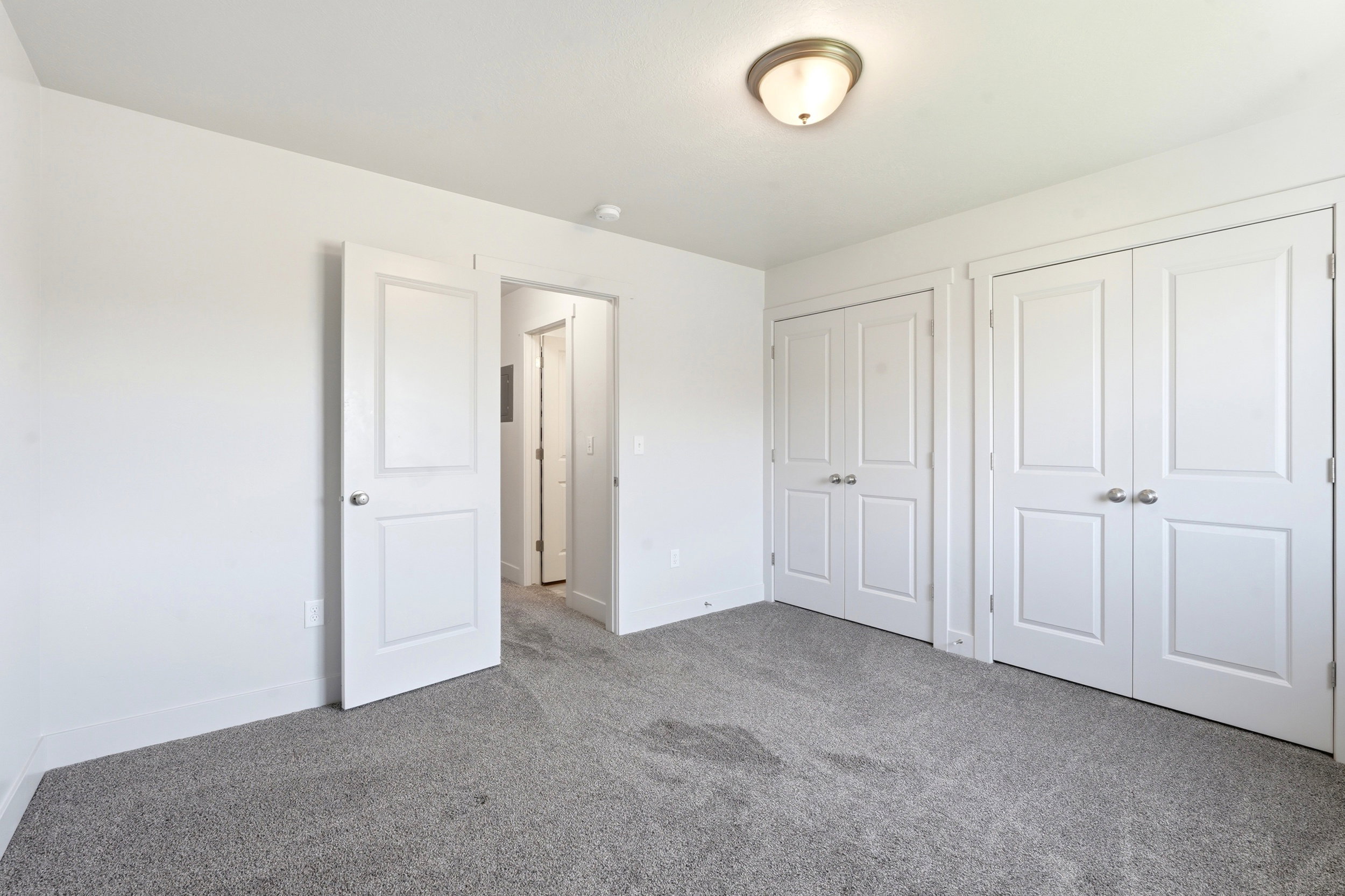 Room featuring grey carpeting, white painted walls, and a semi-flush mount ceiling light fixture