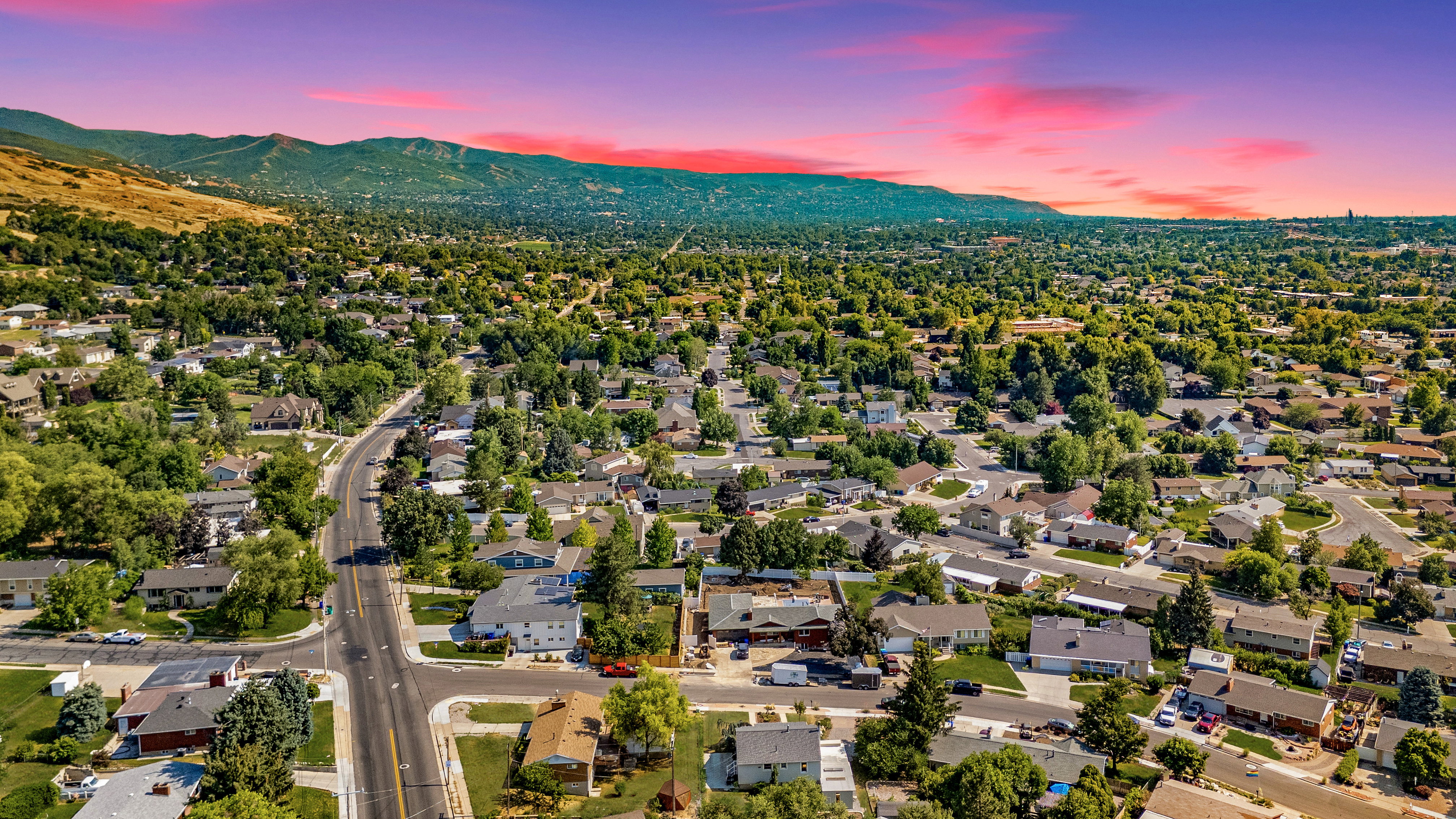 Sprawling residential area featuring numerous single-family homes with mature trees and paved roads