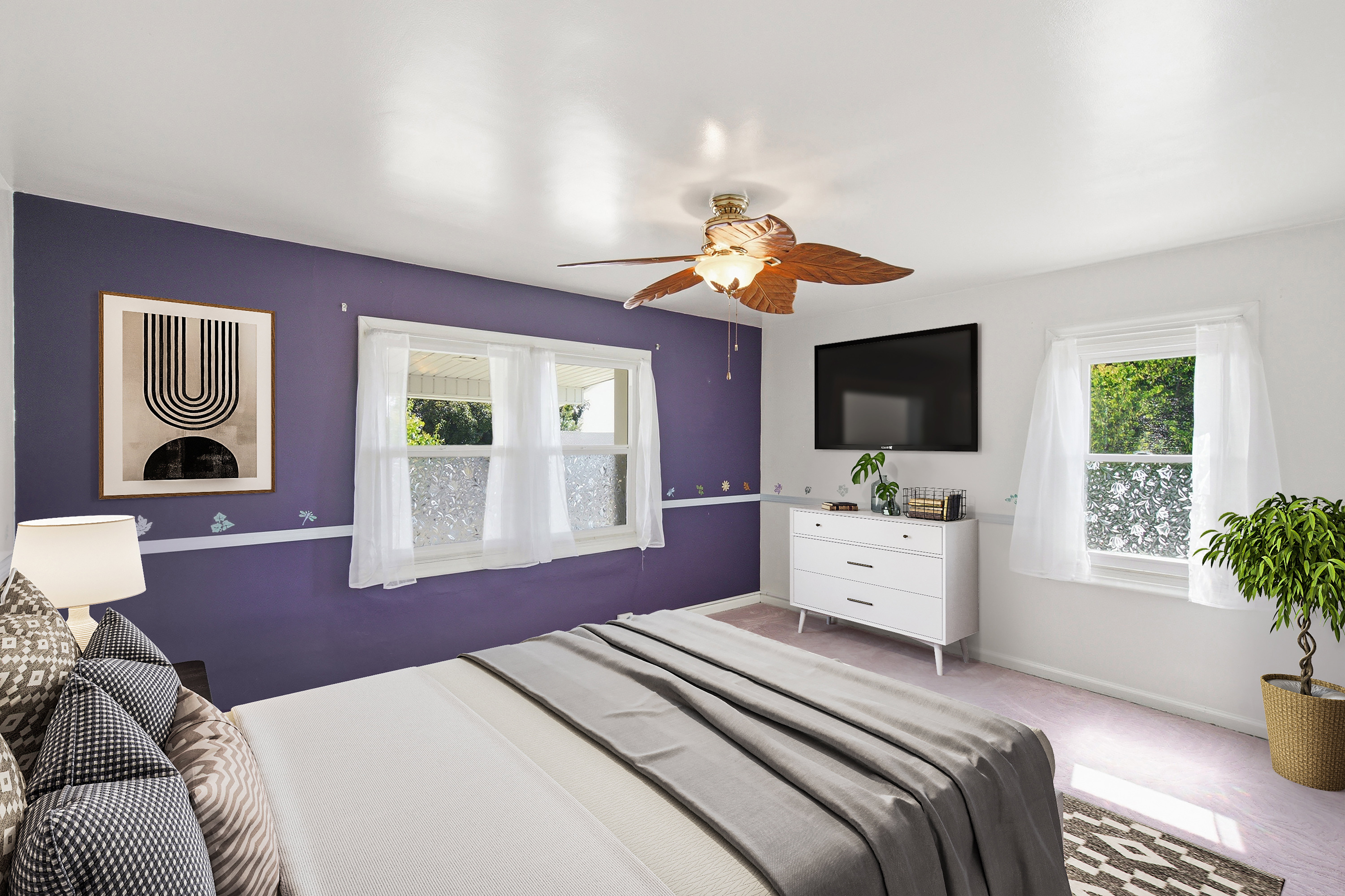 Bright interior space featuring a ceiling fan with integrated lighting, two windows with white trim, and a wall-mounted television