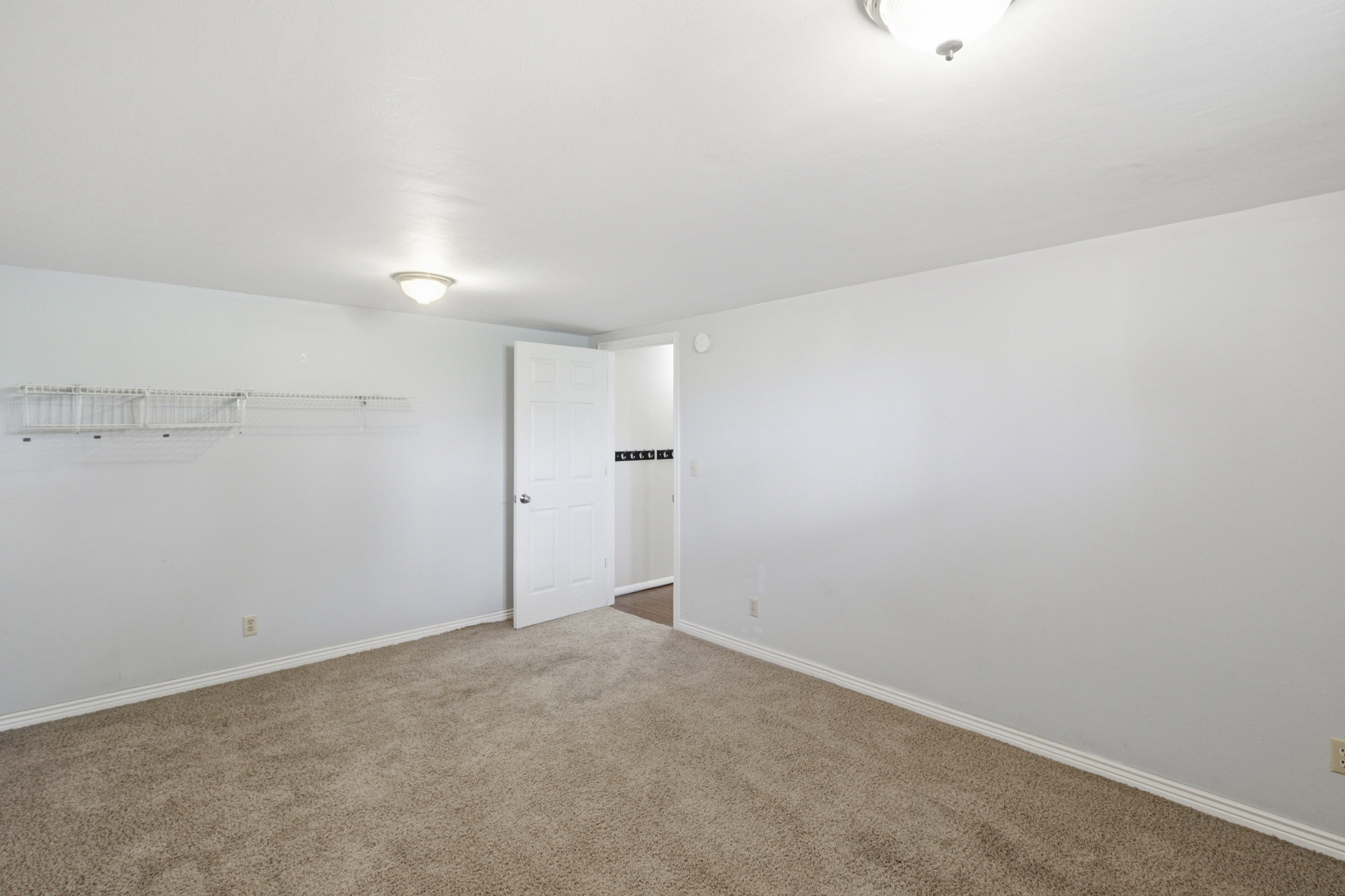 Carpeted room featuring light gray walls, white baseboards, and a semi-flush ceiling light fixture