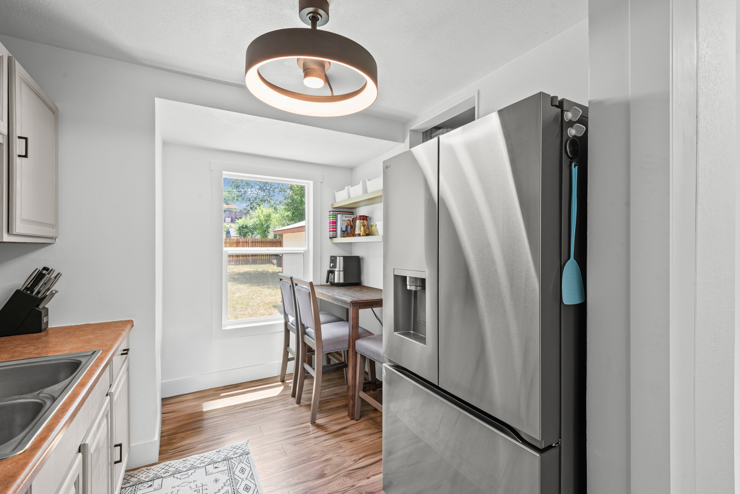 Bright kitchen area featuring a stainless steel French door refrigerator with a water dispenser