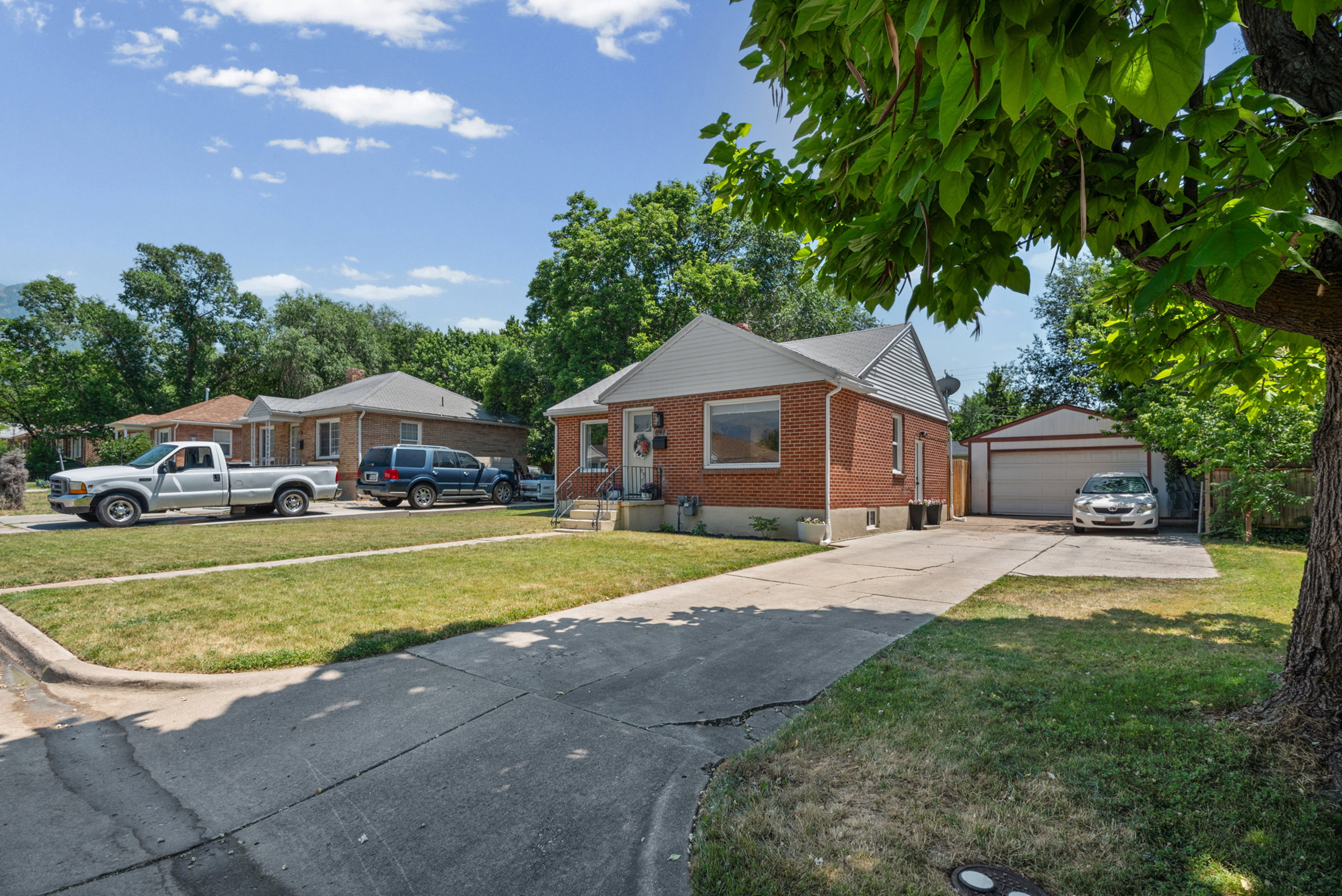 Brick exterior featuring a white gabled roof and front entry