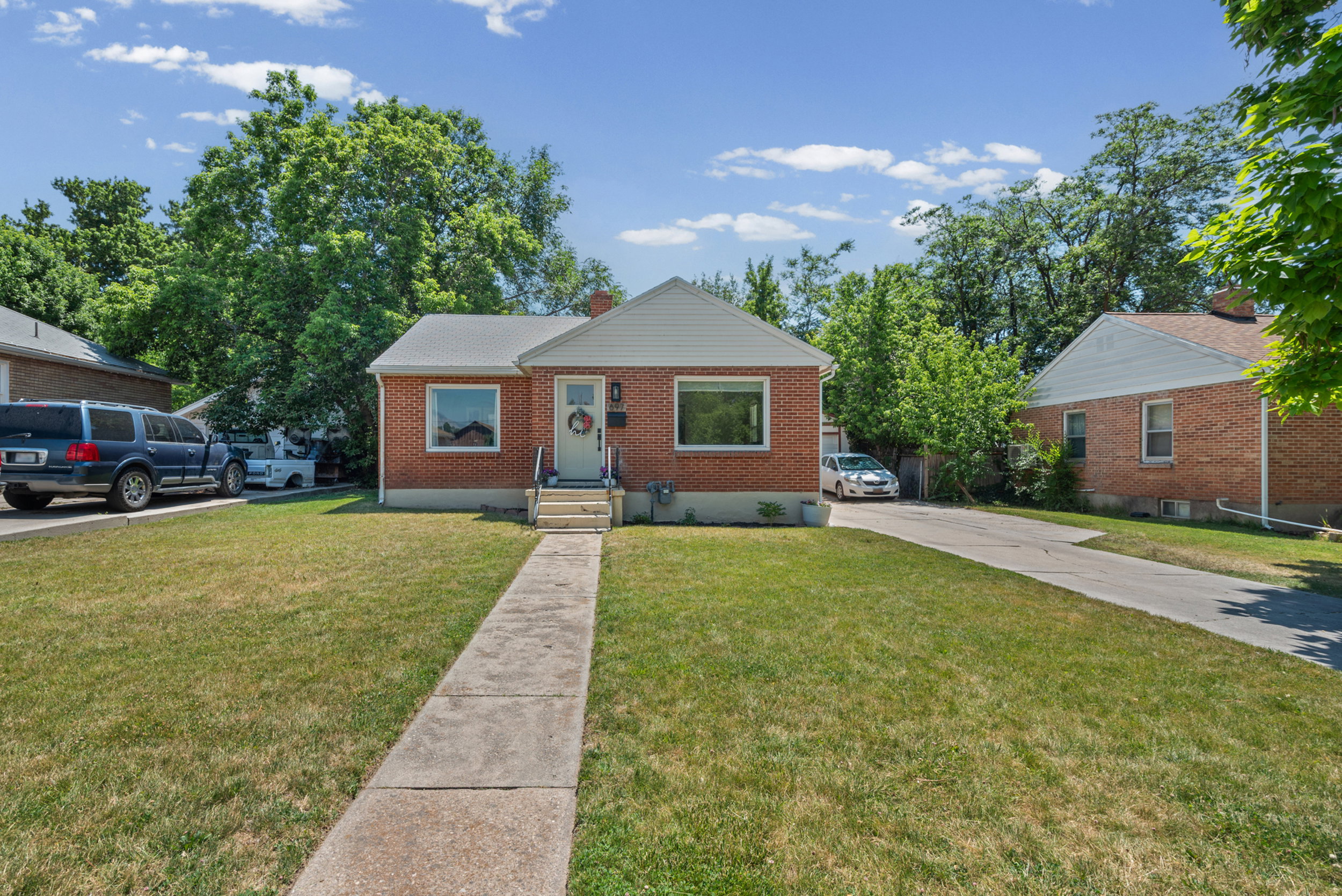 Brick residence with a prominent front lawn and mature trees