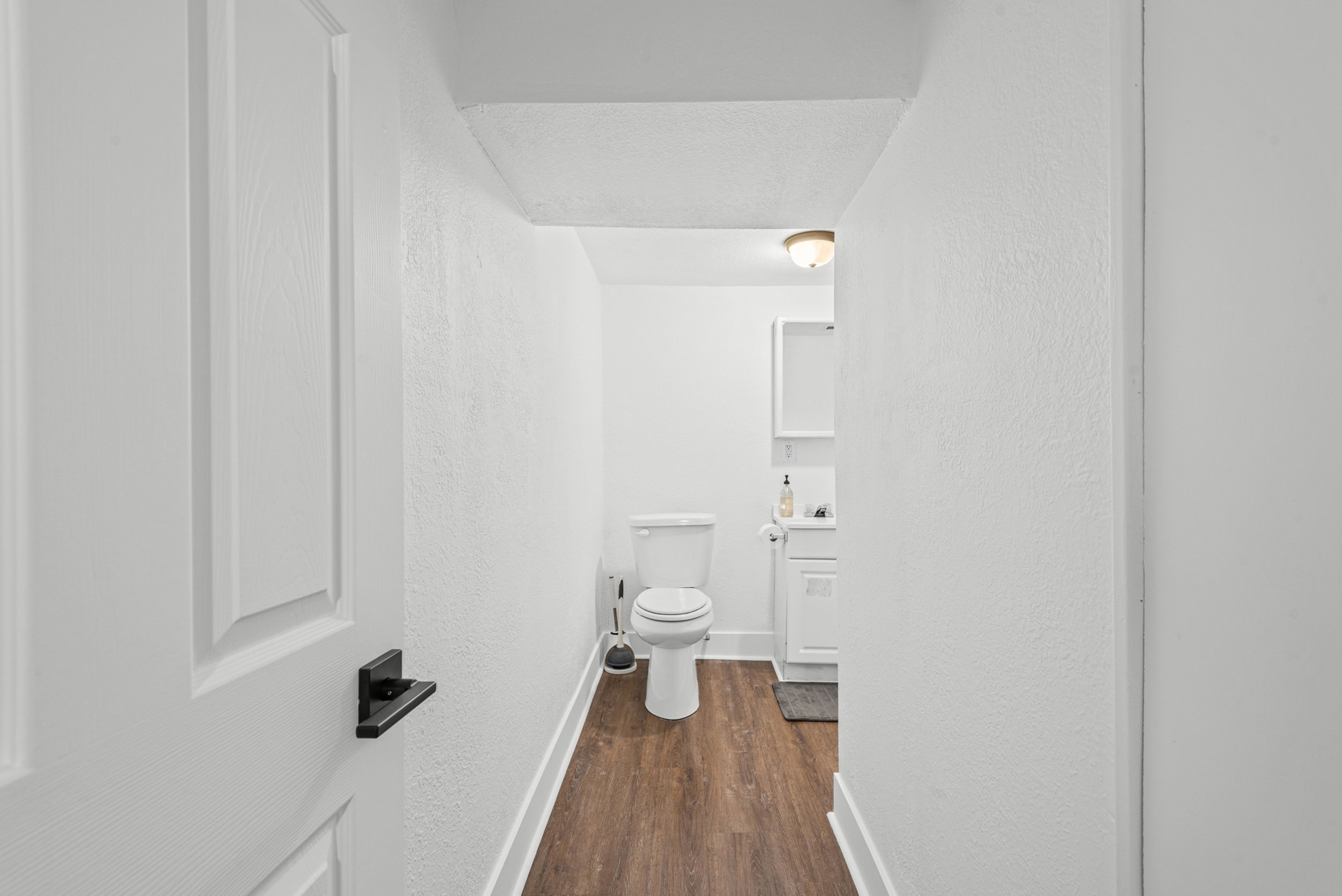 Bathroom featuring wood-finish flooring, white walls, and a recessed ceiling light fixture