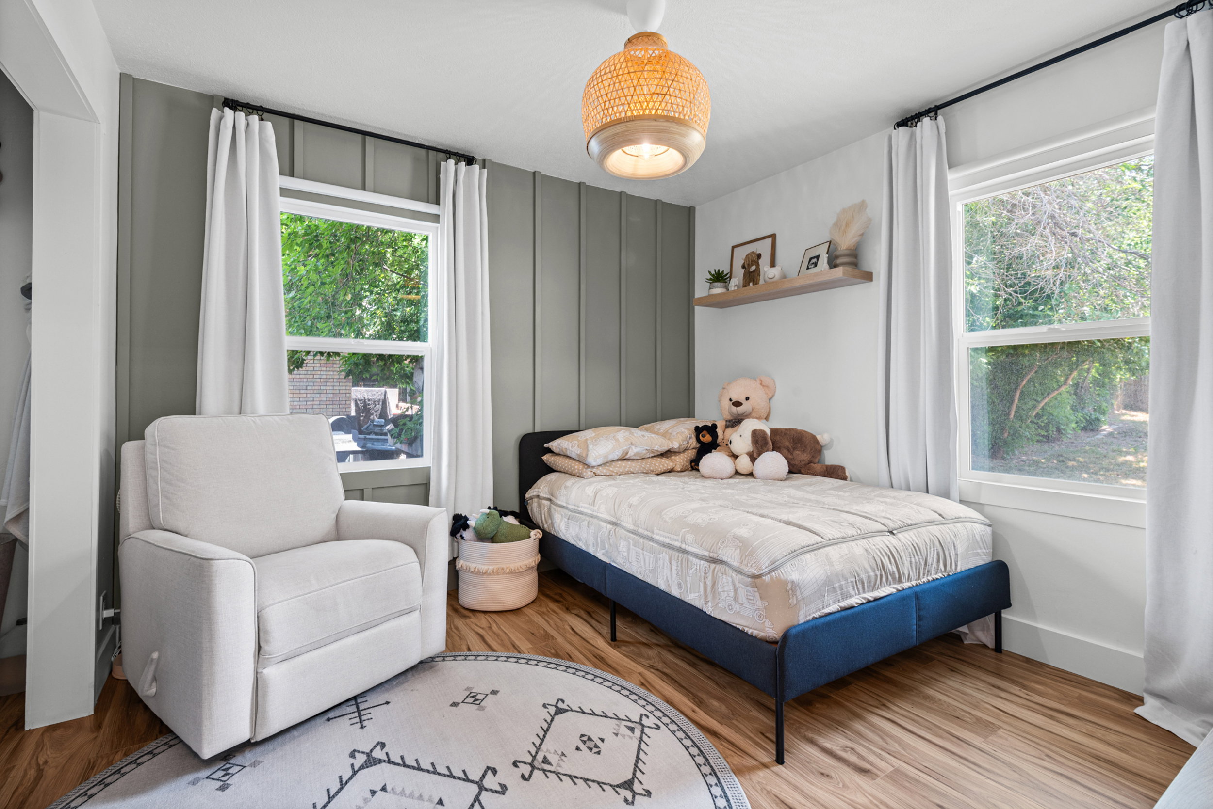 Room with wood-finish flooring, two large windows, and a ceiling-mounted light fixture