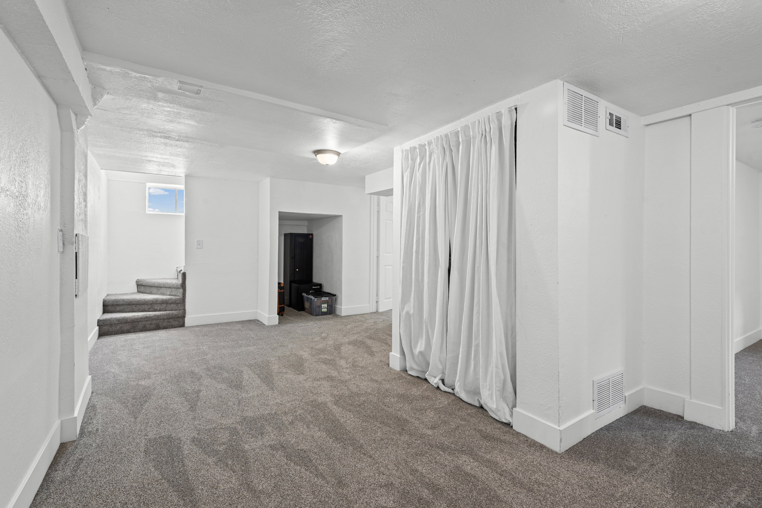 Spacious interior room with gray carpet and white walls