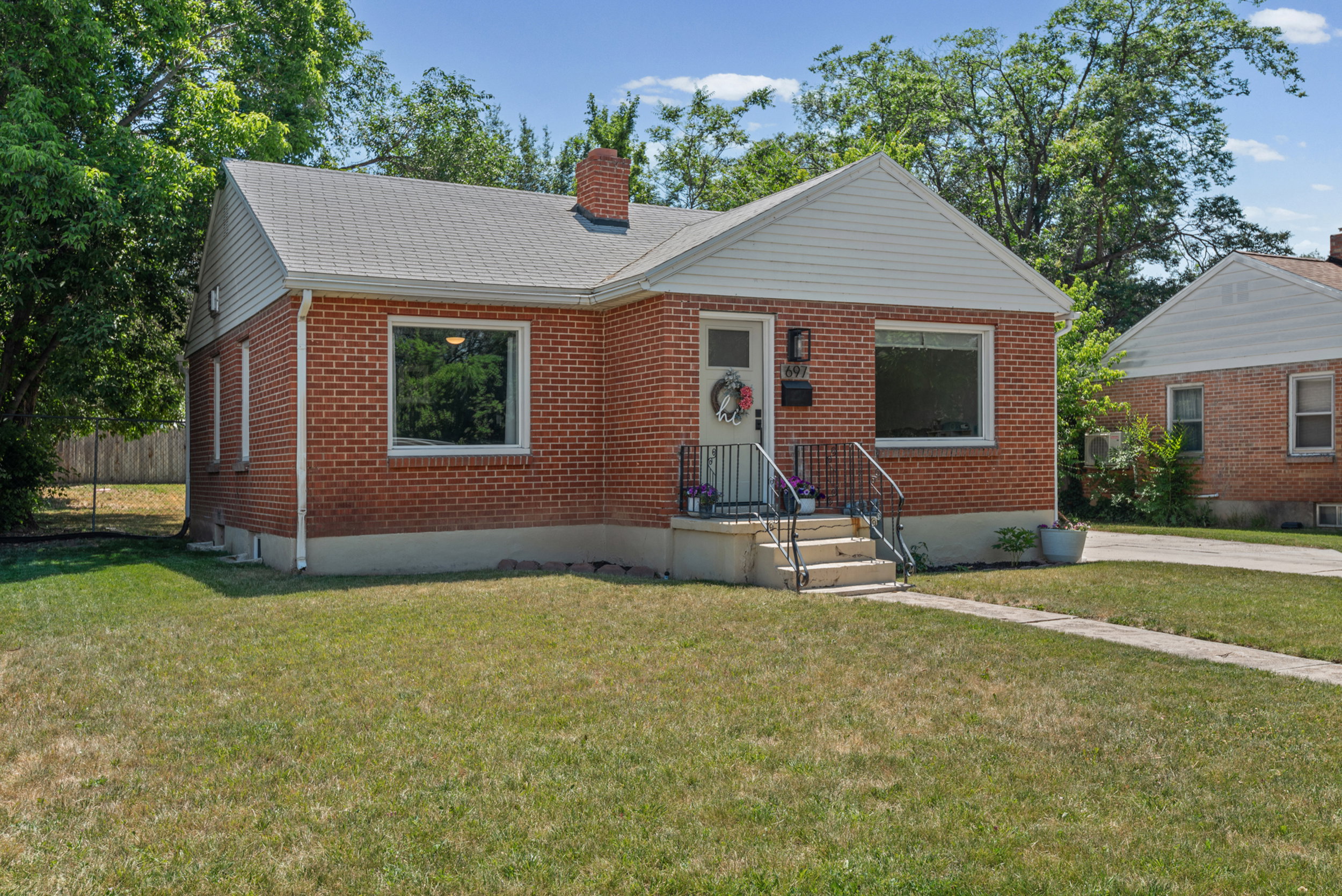 Red brick exterior with white siding accents and a pitched shingle roof