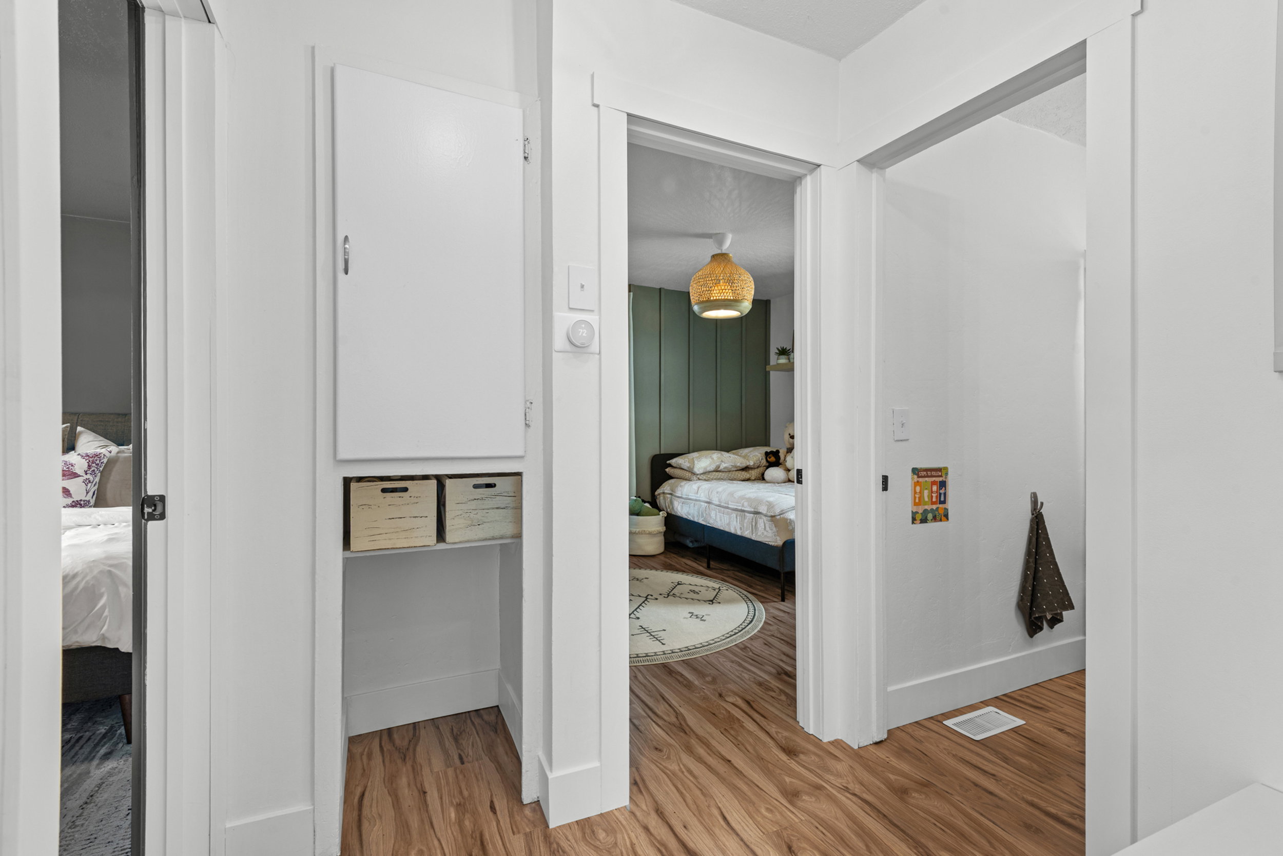 Hallway featuring wood-finish flooring and white baseboards