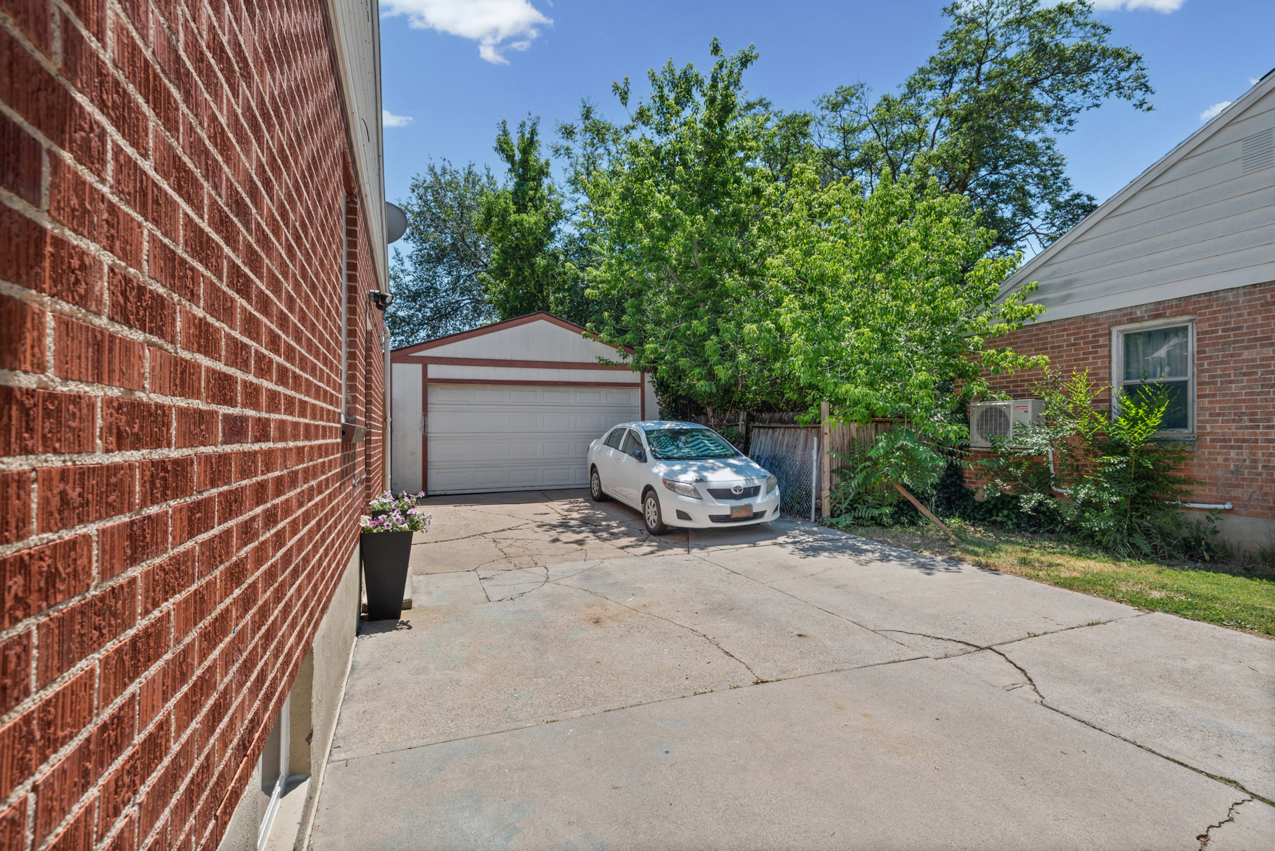Detached garage with a white overhead door and red trim, offering additional storage or parking