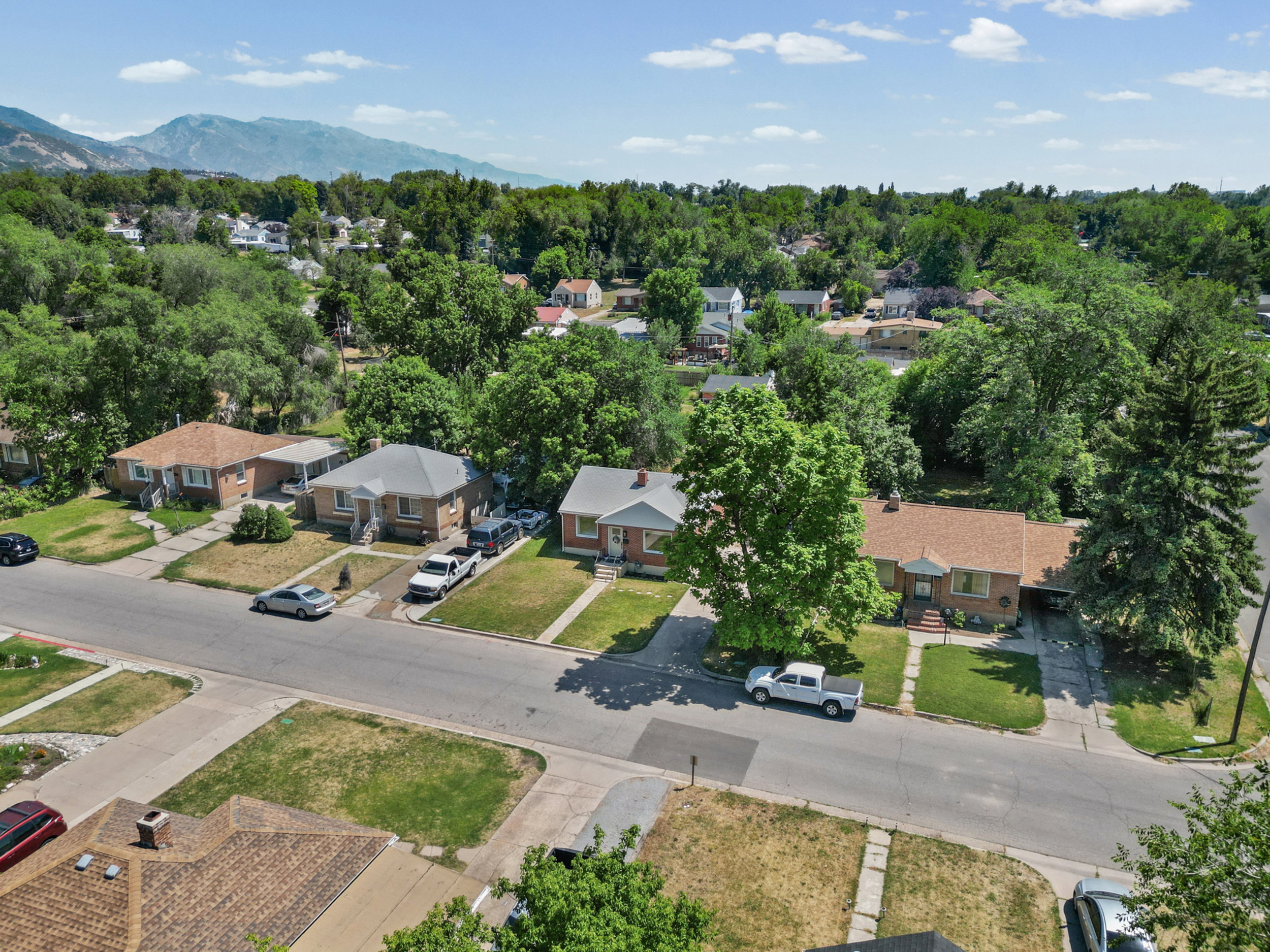 Residential streetscape featuring single-story homes with brick exteriors and various roof styles