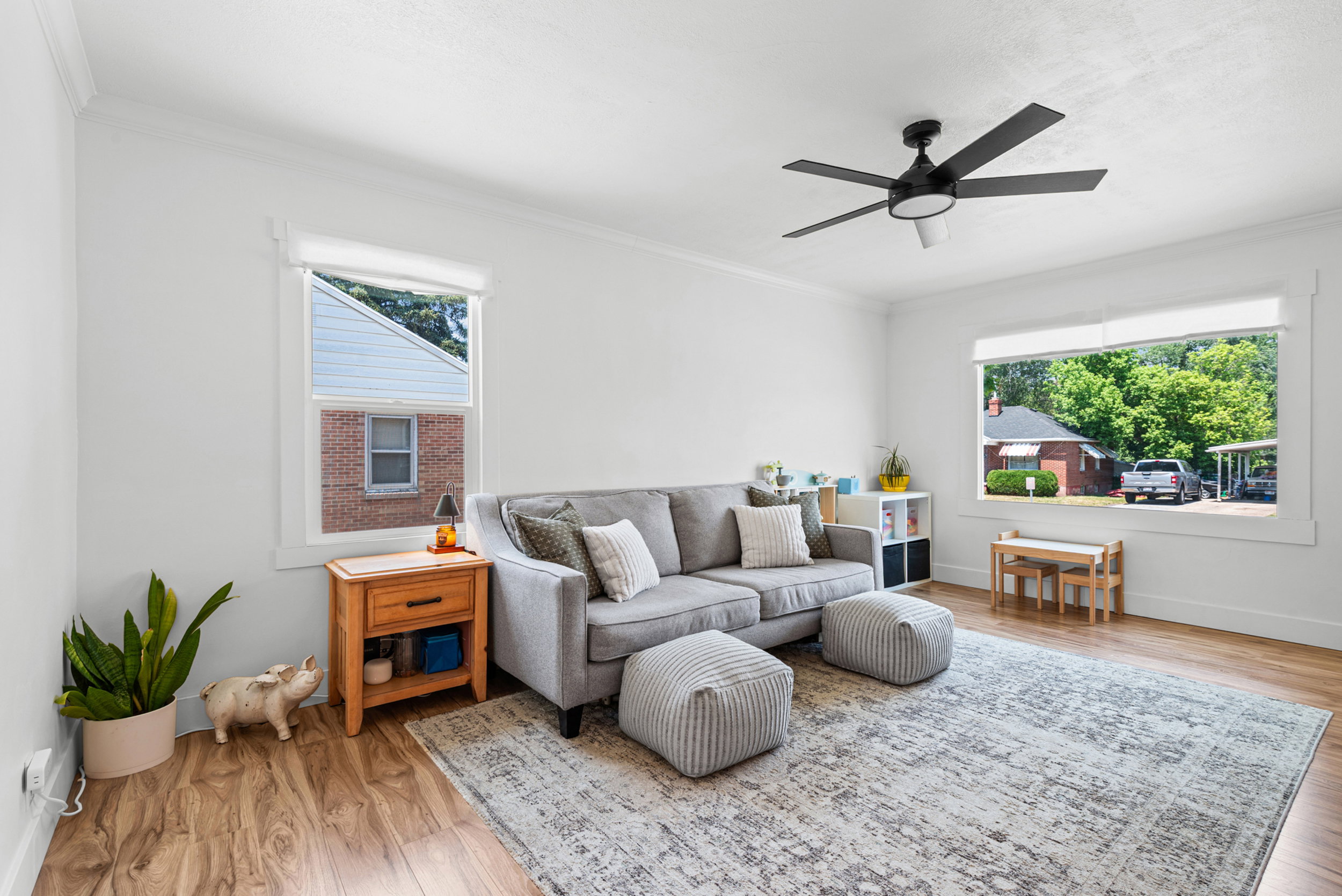 Spacious room featuring wood-finish flooring, white walls, and bright natural light from multiple windows