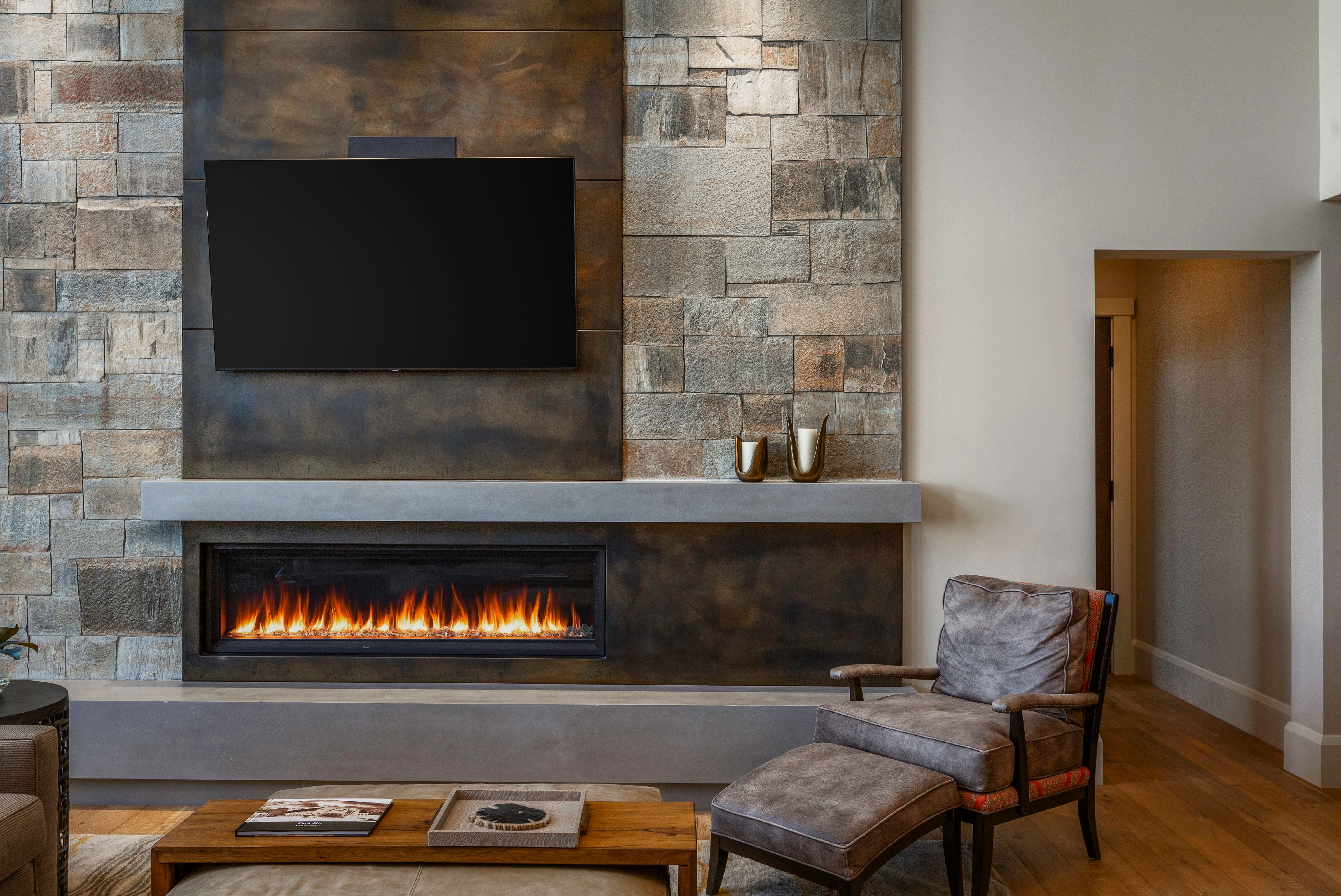Floor-to-ceiling stone fireplace surround with a linear gas fireplace