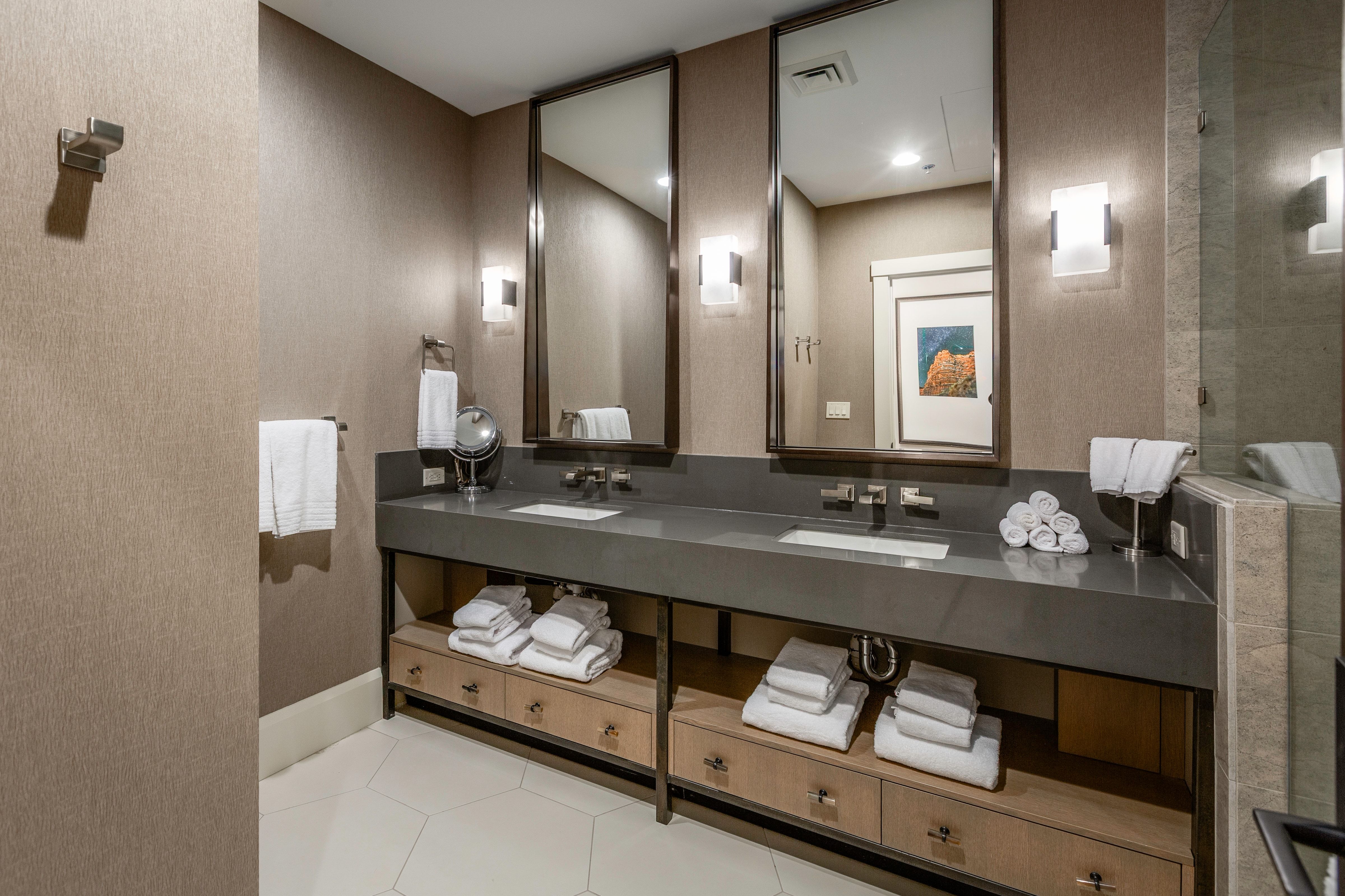 Dual vanity with an integrated rectangular sink, dark countertop, and two framed mirrors