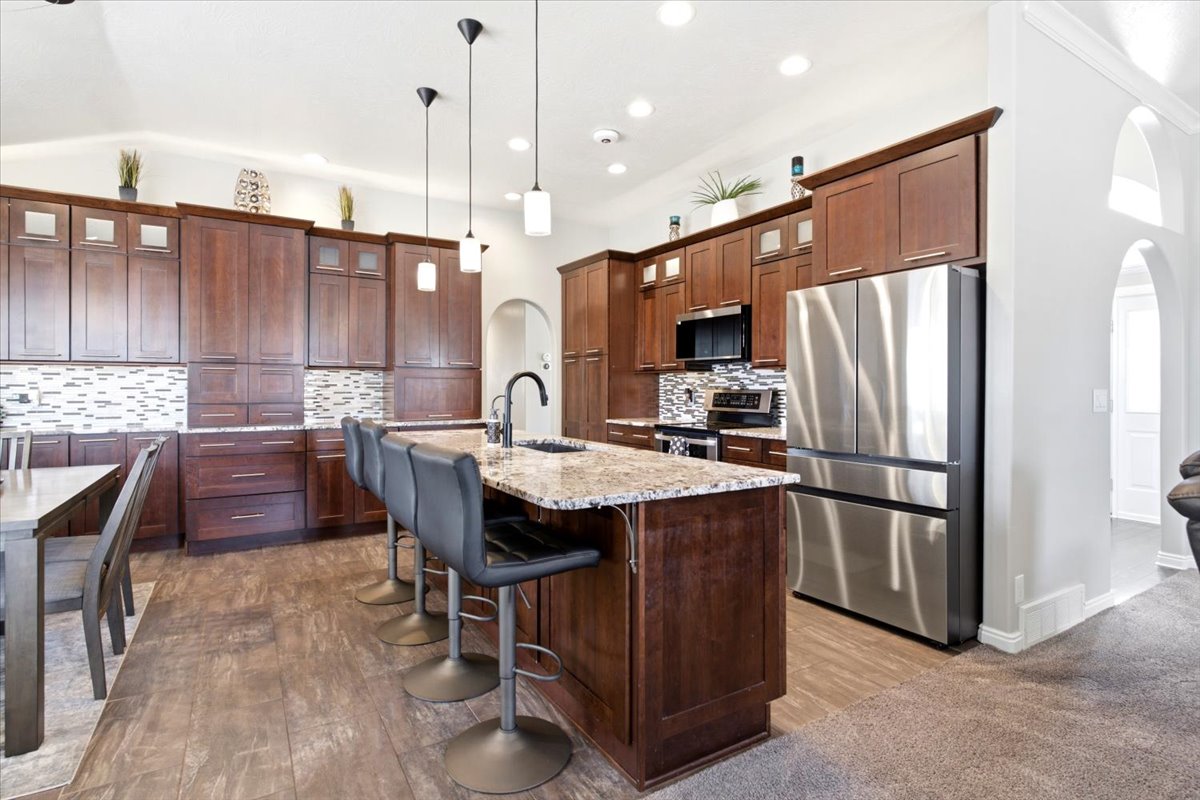 Updated kitchen features granite counters, 10' island, composite granite single-basin sink, stainless steel appliances, tall cabinetry, pull-outs, soft-close drawers and cabinets, pantry, &  broom closet