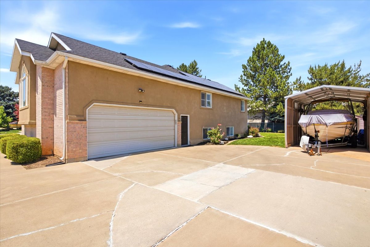 Oversized garage with workshop/storage area and sink, plus covered parking for a vehicle, boat or RV, & a workshop/shed that fits an ATV!